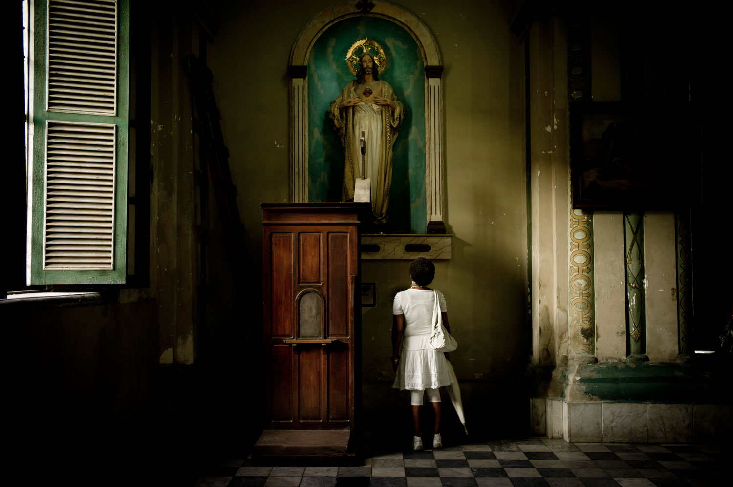 March 19, 2012. A woman, who practices Santería prays at the Cathedral of Santiago de Cuba.