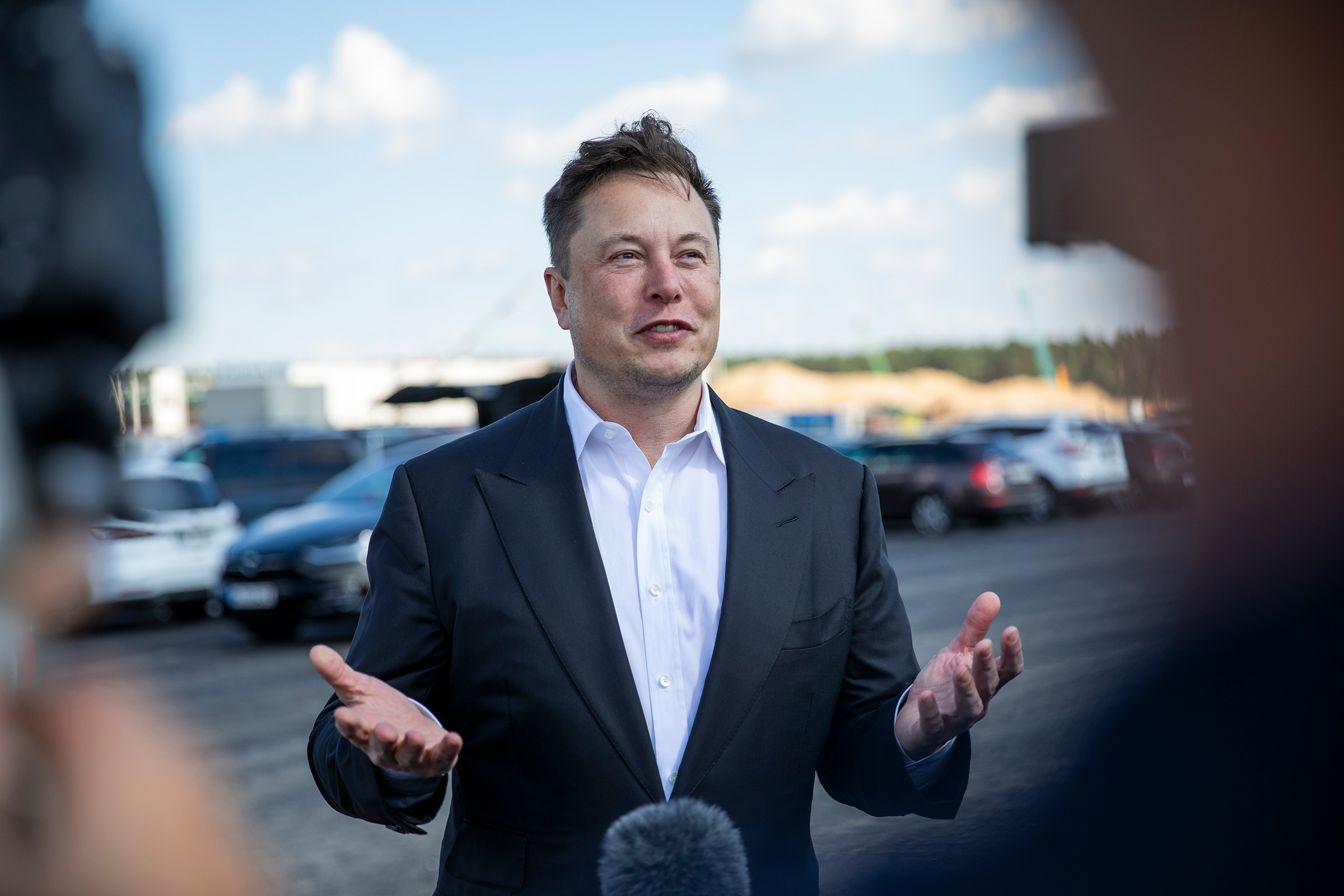 Elon Musk talks to the press as he arrives to  see the construction site of the new Tesla Gigafactory near Berlin