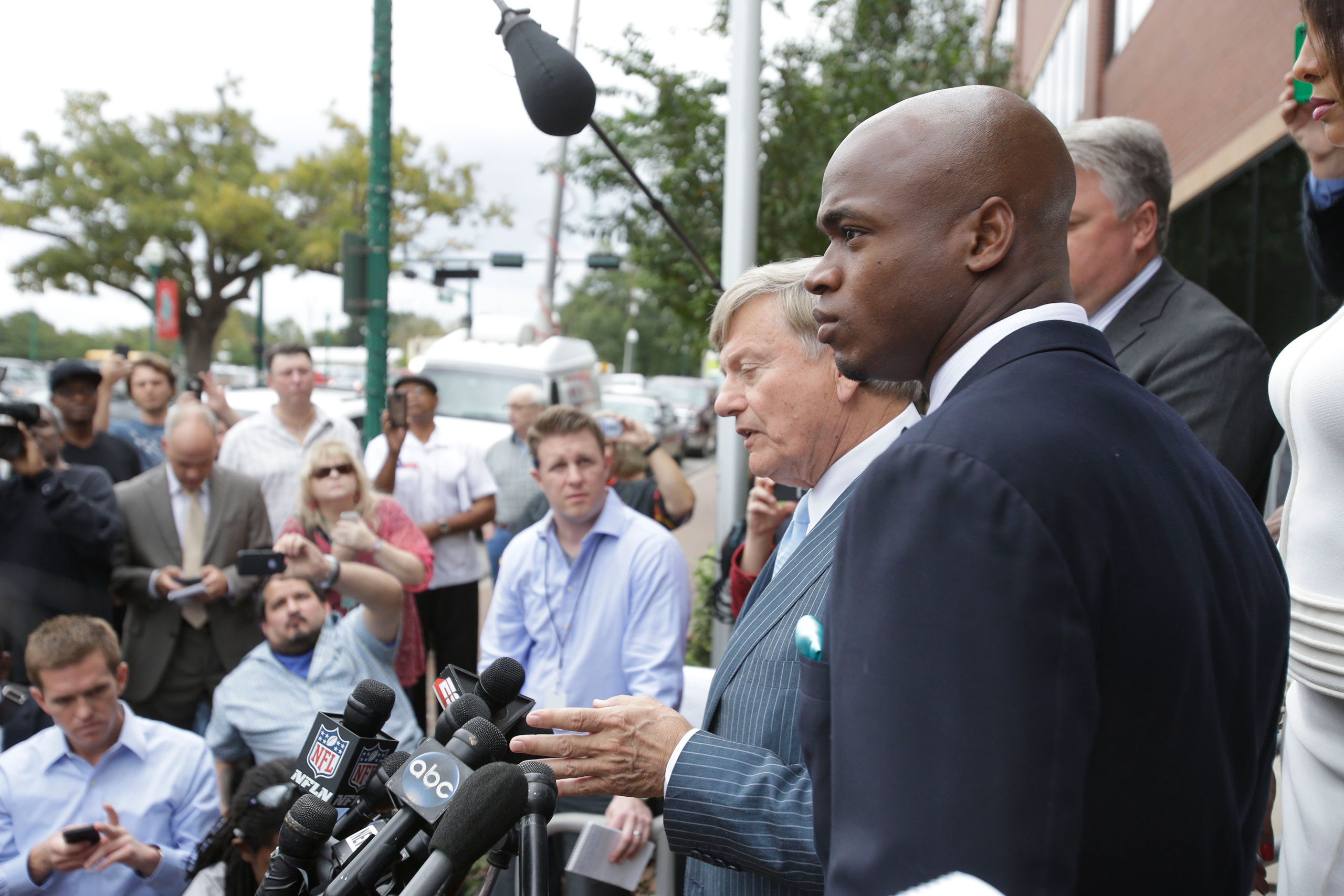 From right: Minnesota Vikings running back Adrian Peterson and his attorney Rusty Hardin speak to the media after pleading no contest to an assault charge on Nov. 4, 2014, in Conroe, Tx.