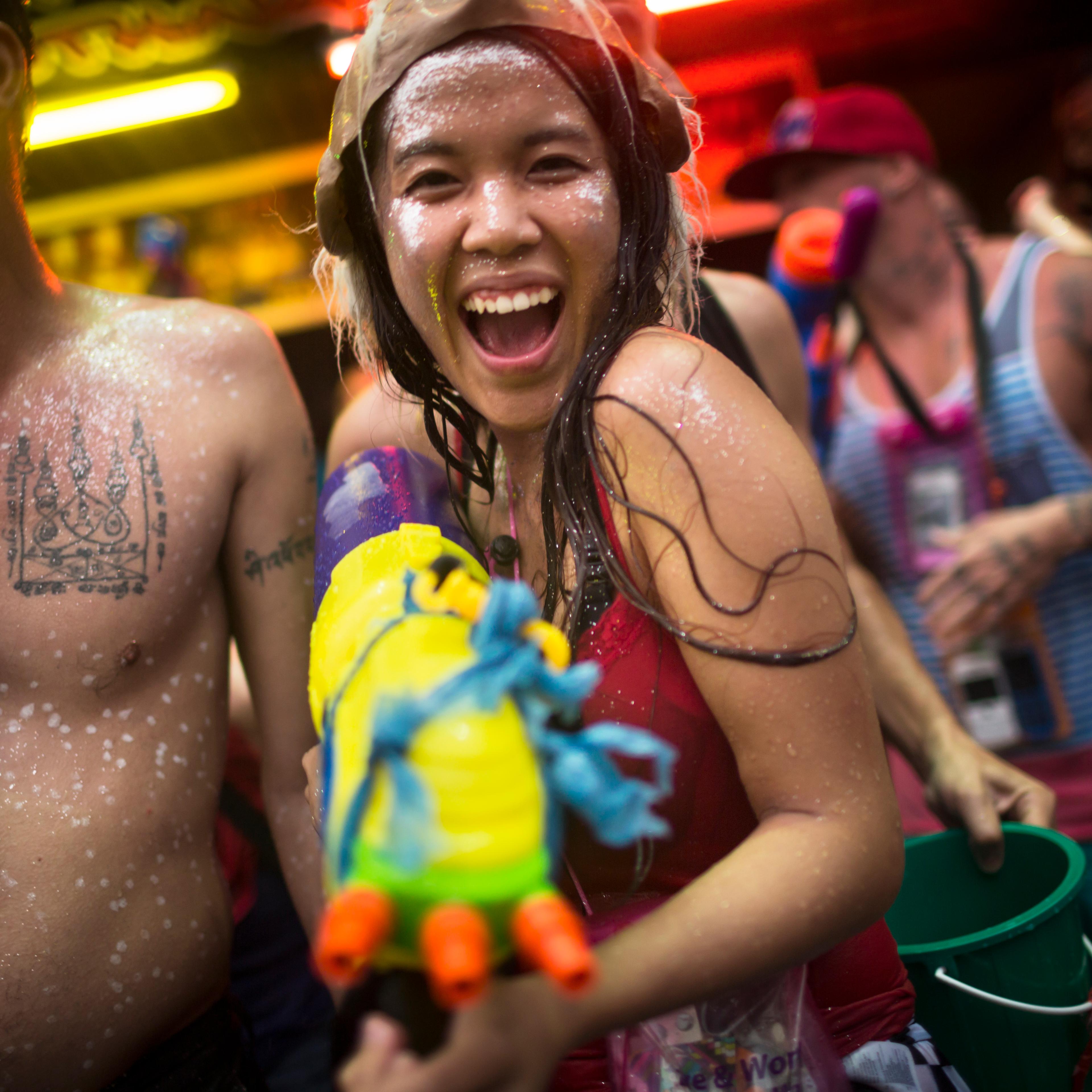 Tourist with water gun celebrates during Songkran