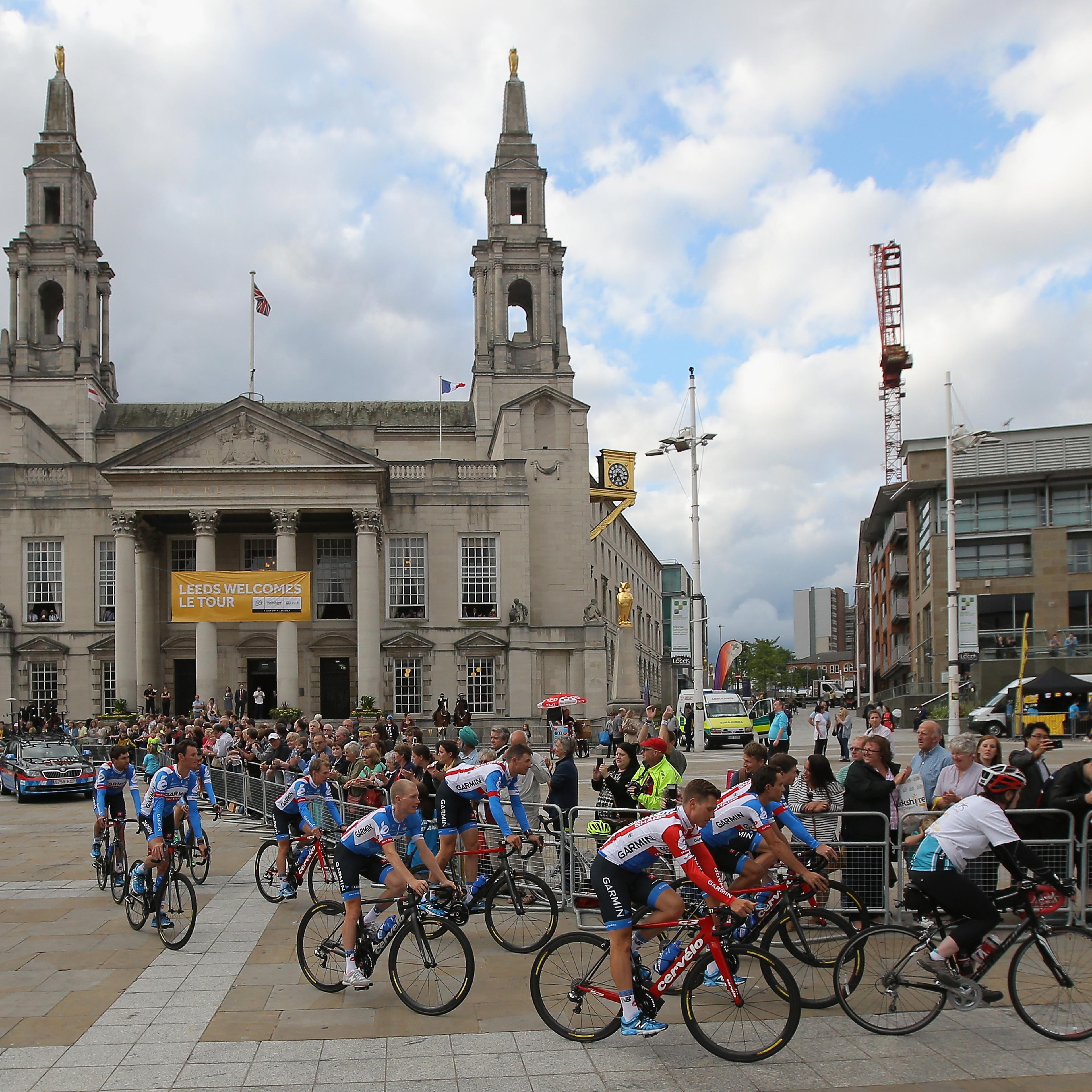Team Garmin-Sharp is greeted by supporters as they ride through Millenium Square enroute to the Team Presentation prior to the 2014 Le Tour de France on July 3, 2014 in Leeds, United Kingdom.