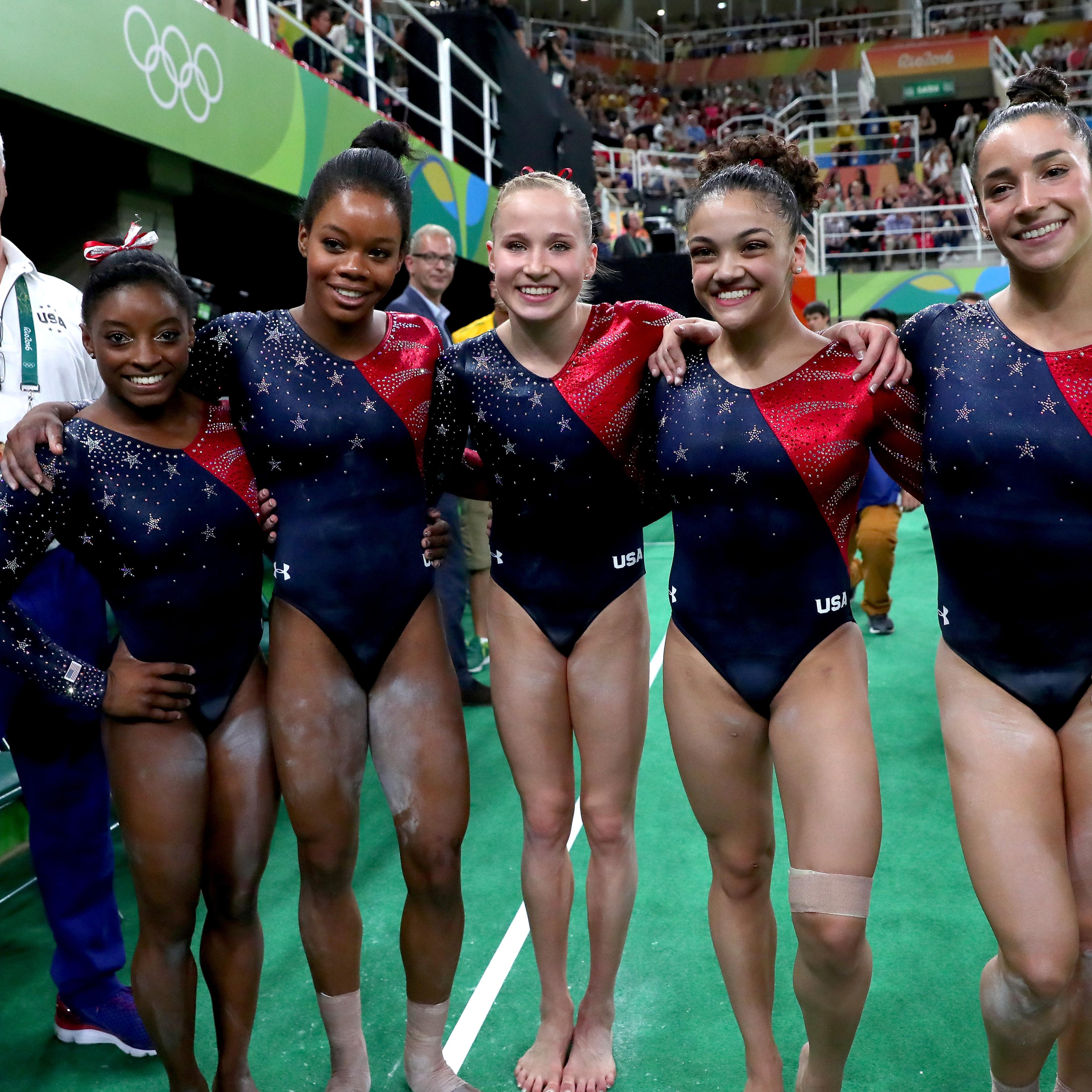 (L to R) Coach Mihai Brestyan, Simone Biles, Gabrielle Douglas, Madison Kocian, Lauren Hernandez and Alexandra Raisman of the United States pose for photographs after Women's qualification for Artistic Gymnastics on Day 2 of the Rio 2016 Olympic Games at