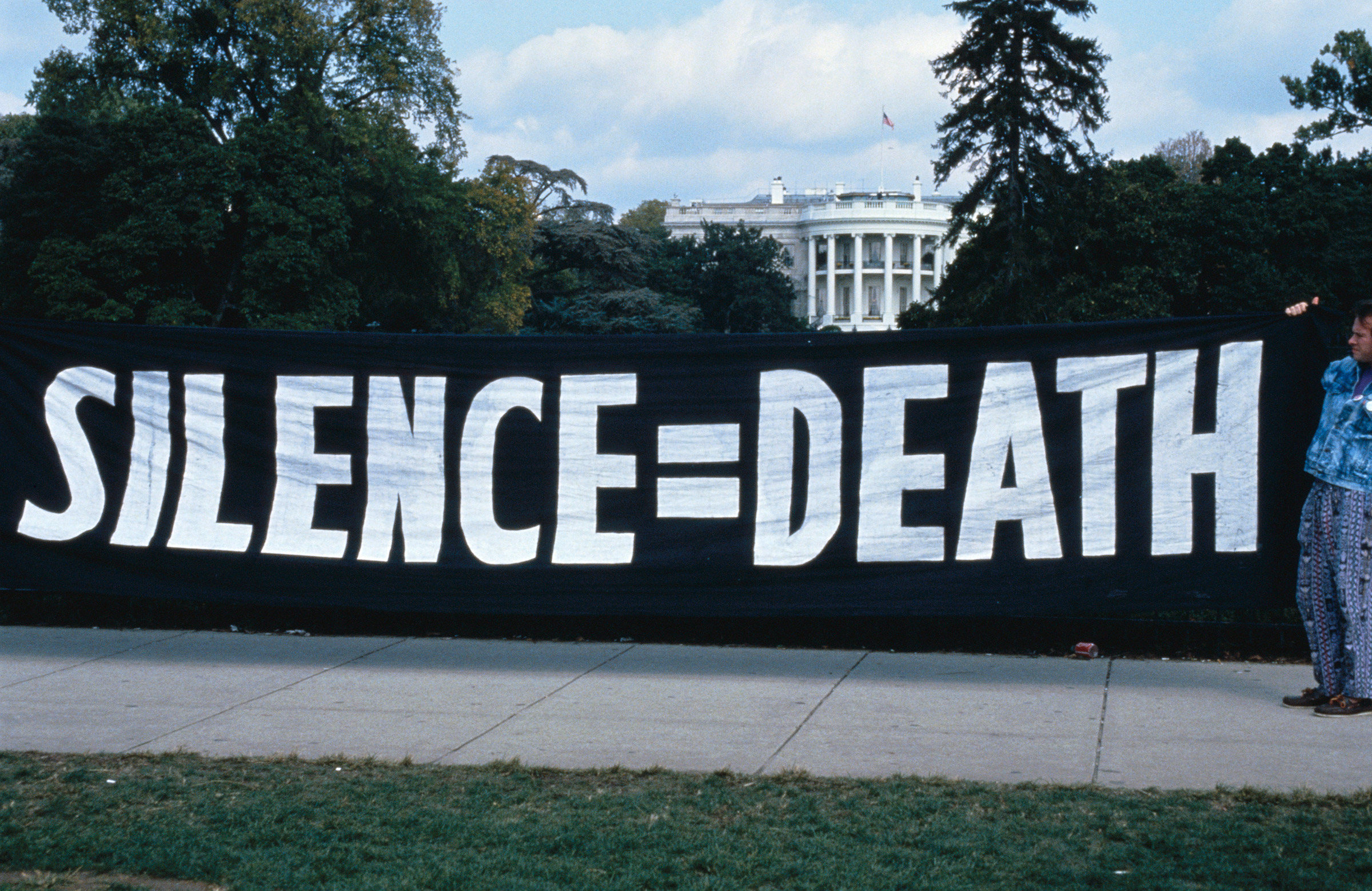 ACT UP activists hang a banner outside of the White House in Washington, D.C.