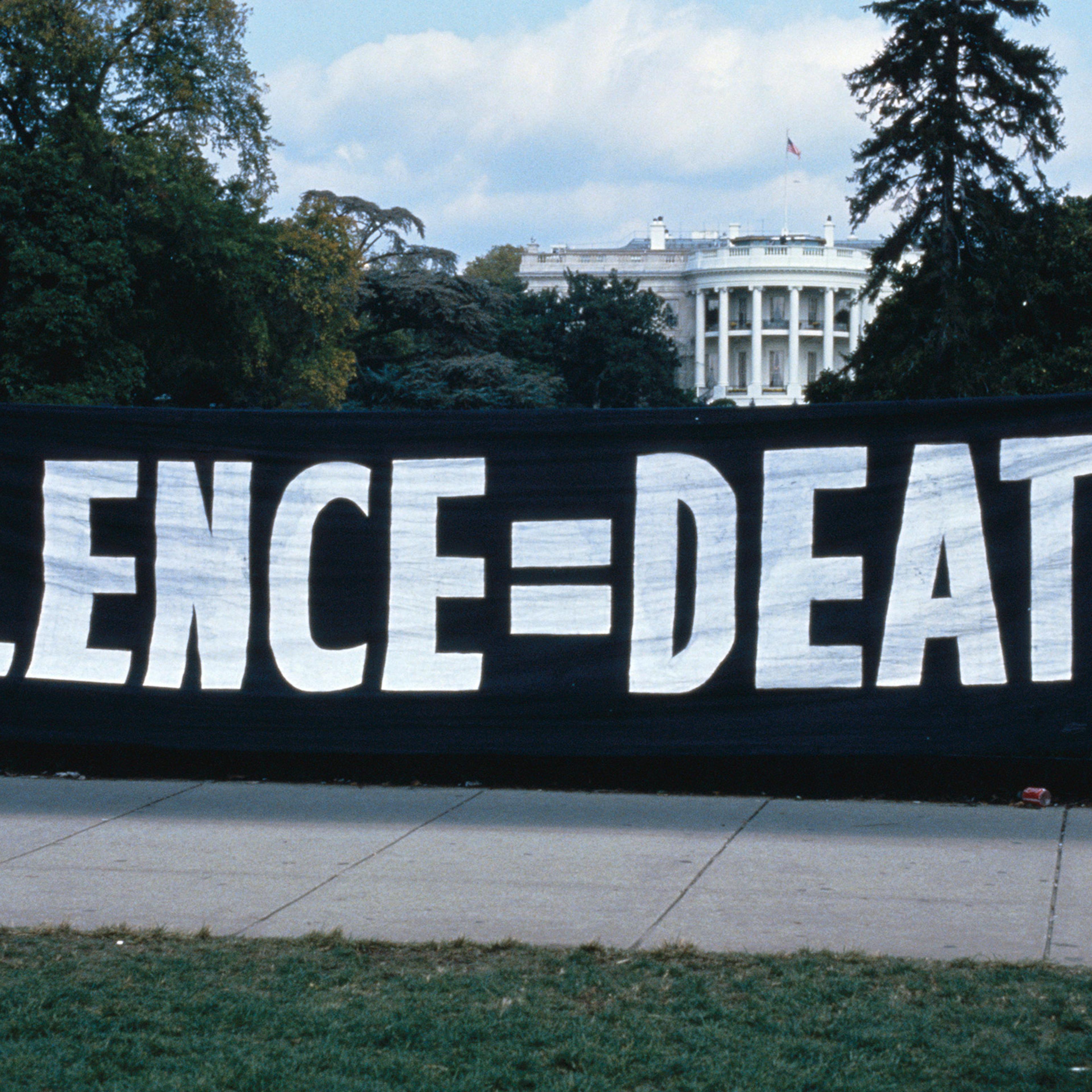 ACT UP activists hang a banner outside of the White House in Washington, D.C.
