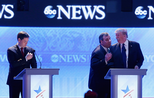 Republican presidential candidates New Jersey Governor Chris Christie (2nd R) and Donald Trump visit as Sen. Marco Rubio (R-FL) (L) stands close by during a commercial break in the Republican presidential debate at St. Anselm College February 6, 2016 in 