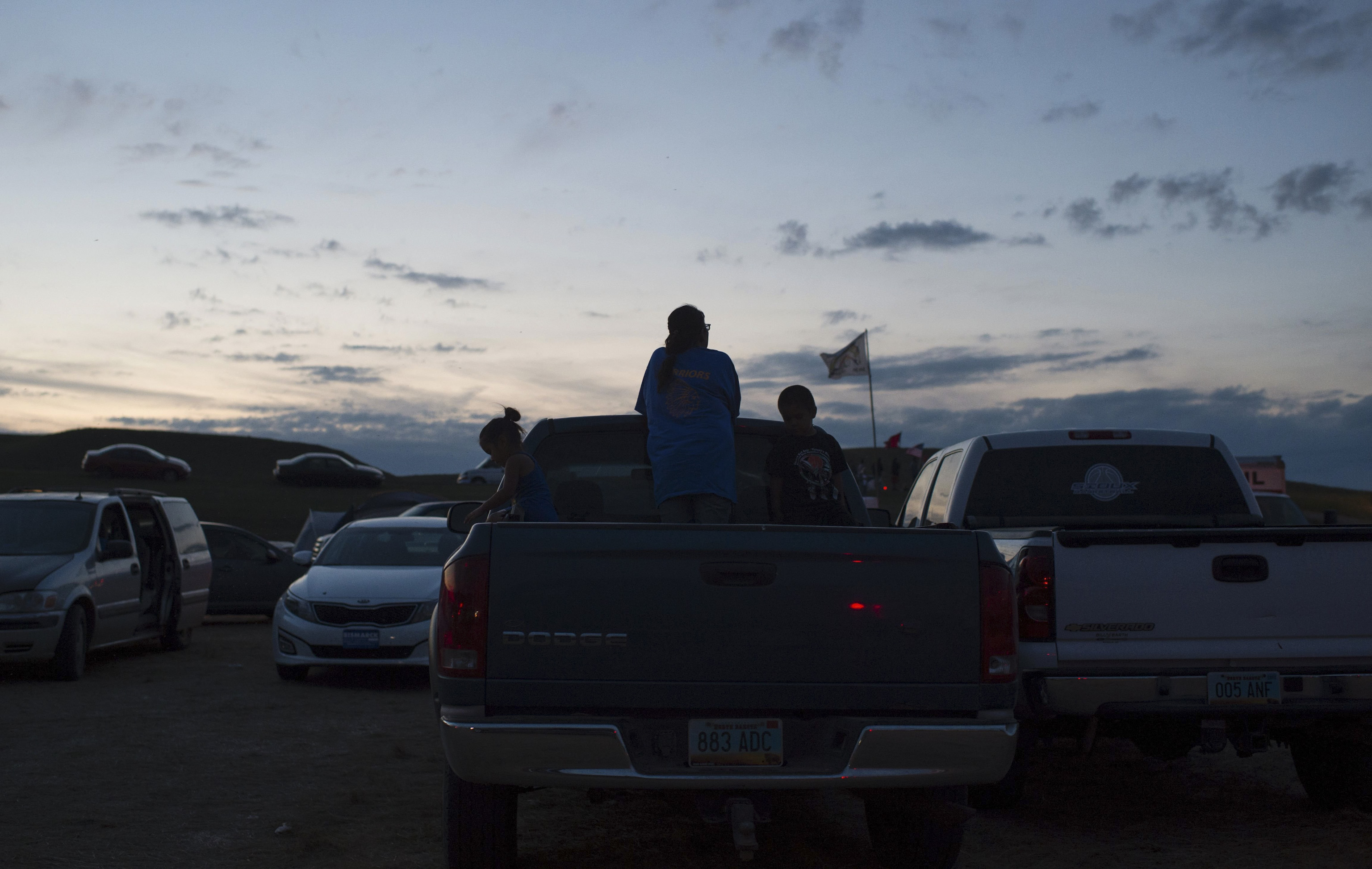 People hang out in the bed of their truck as the sun sets over a protest encampment near Cannon Ball, North Dakota on Sept. 3, 2016.