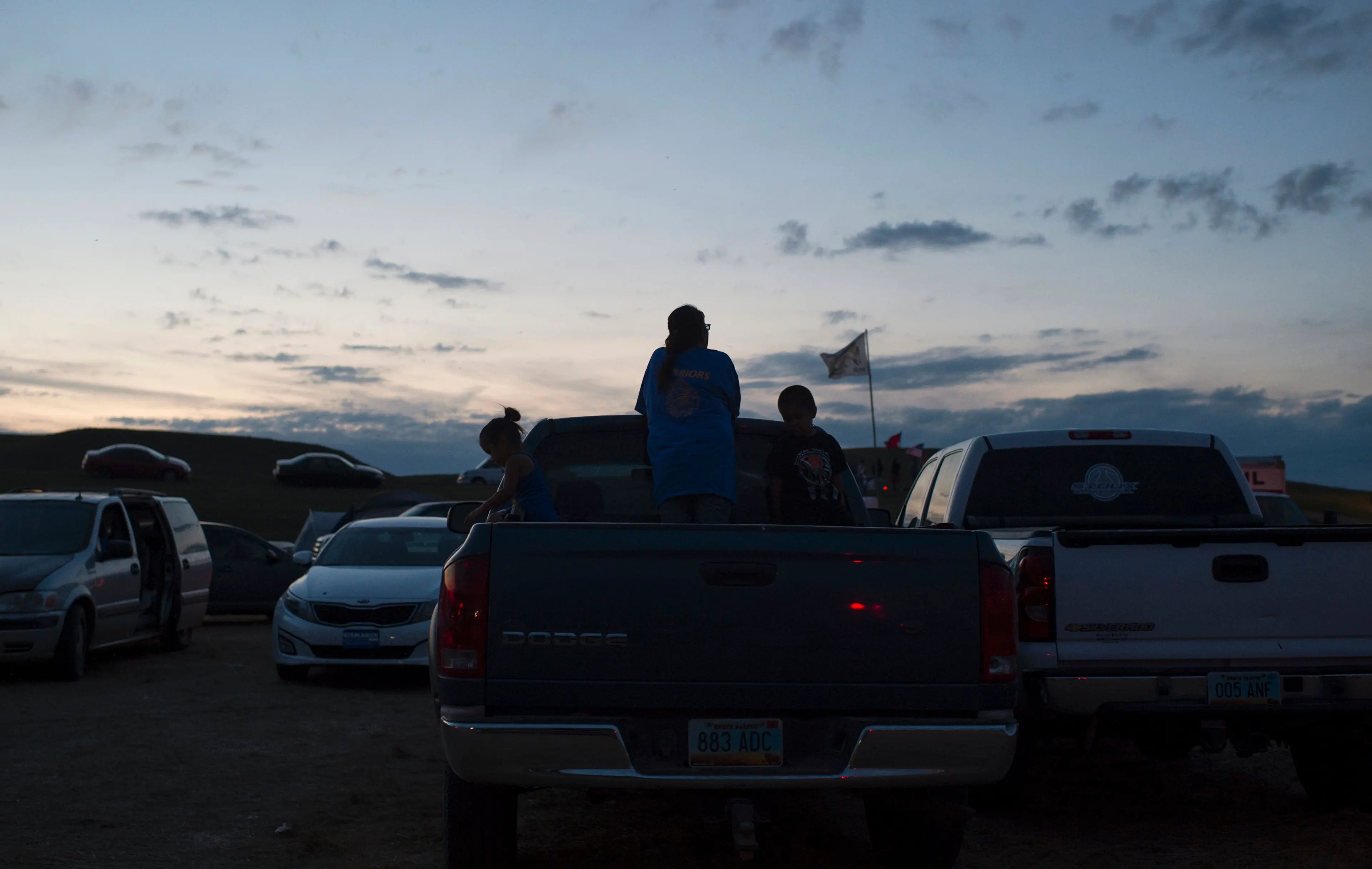 People hang out in the bed of their truck as the sun sets over a protest encampment near Cannon Ball, North Dakota on Sept. 3, 2016.