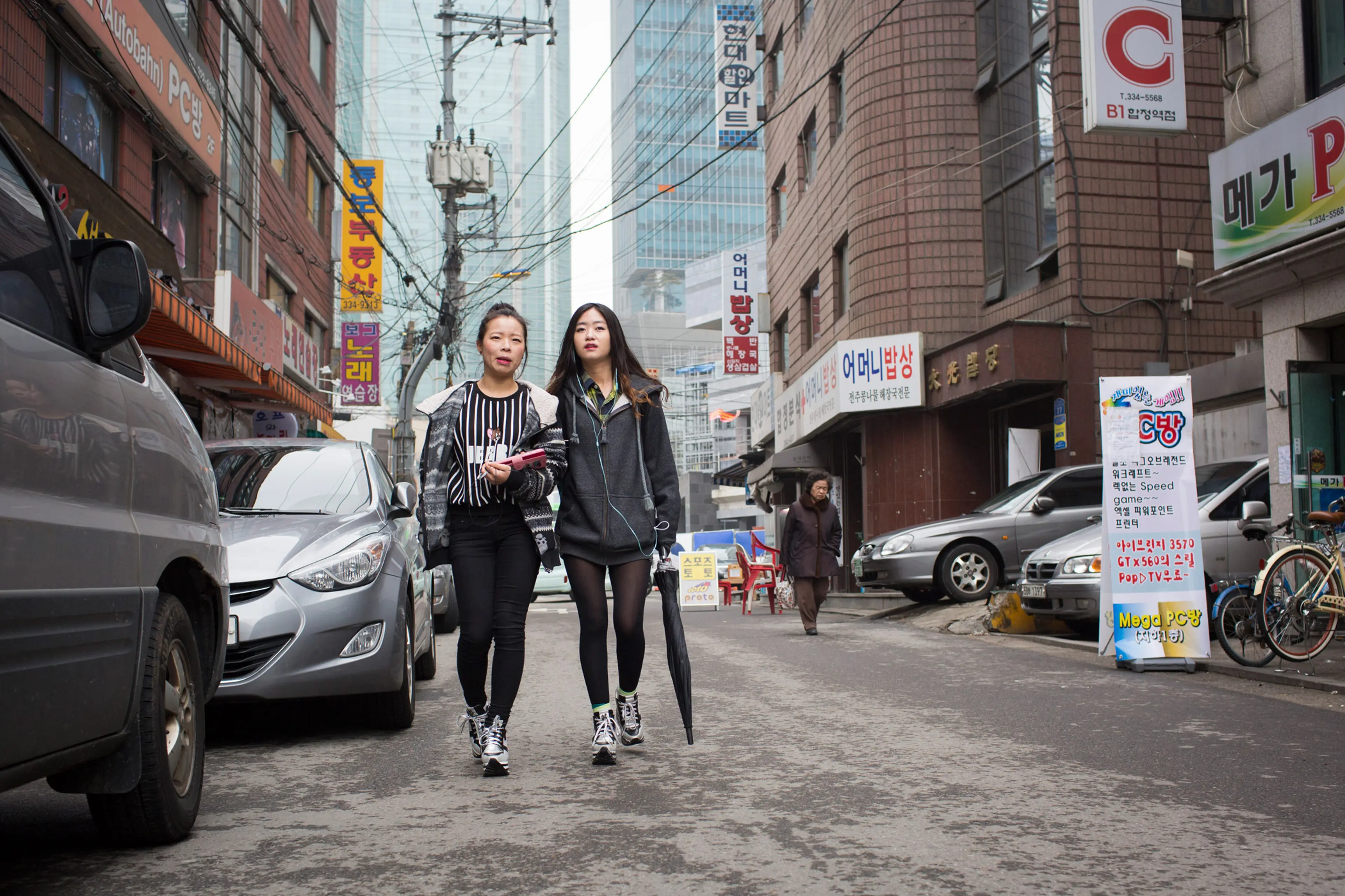 Donning matching shoes, North Korean refugees Kim Kyong-ok, 19 (Lunar age), and Sarah (English name used in order to protect source), 22, walk arm-in-arm on their way to a Christian church service on Feb. 21, 2015 near Hapjeong, Seoul, South Korea. The w
