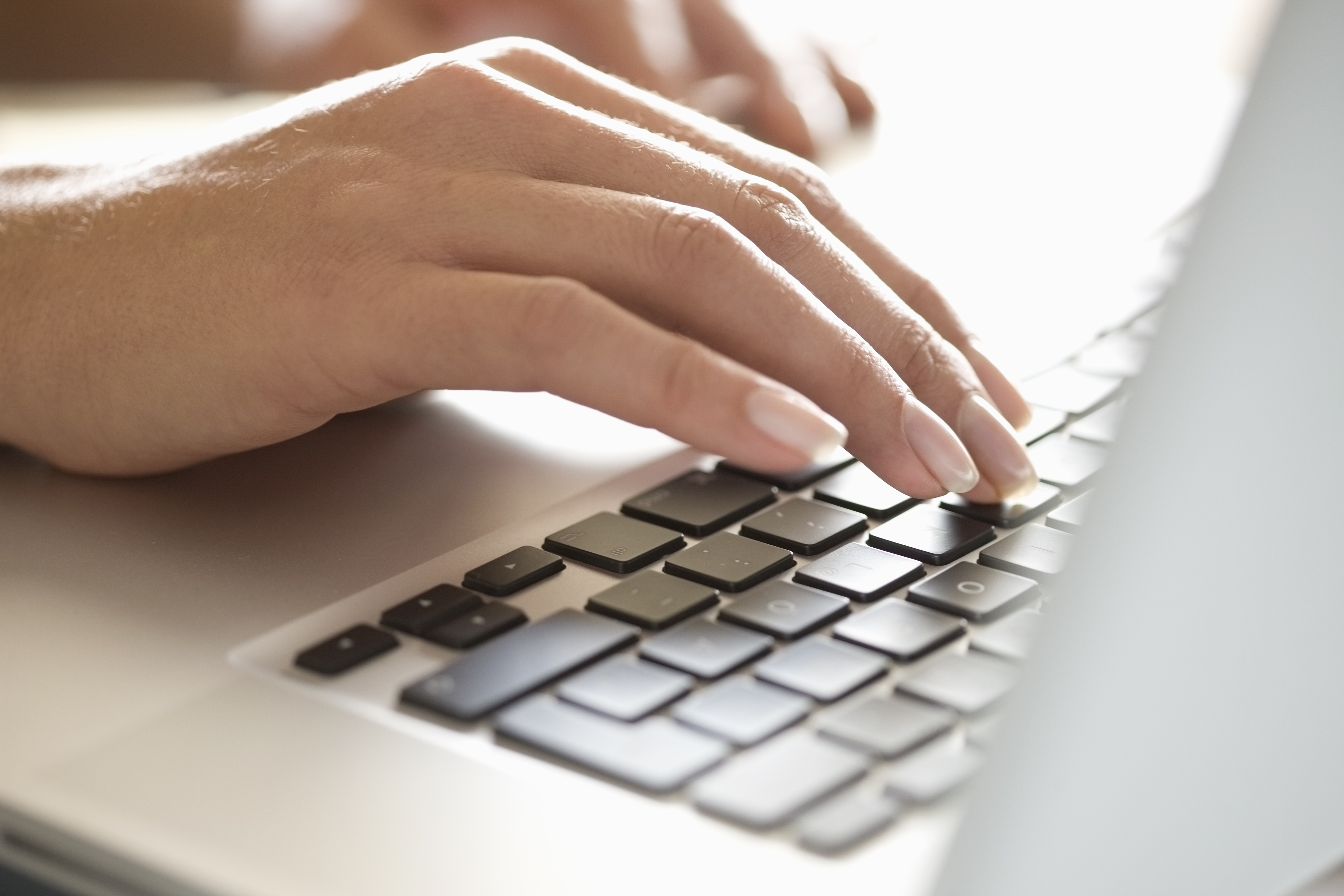 Close up of woman typing on laptop