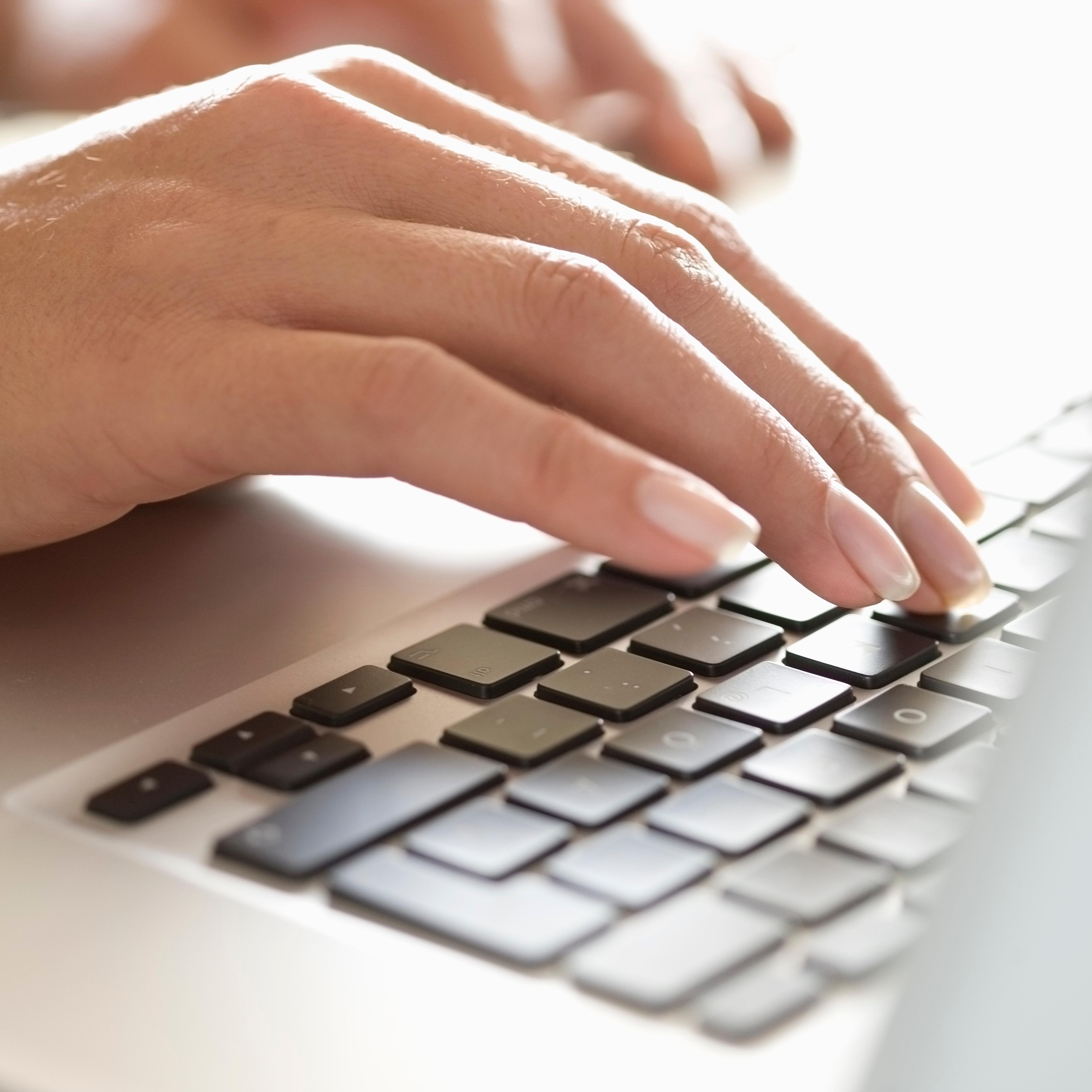 Close up of woman typing on laptop