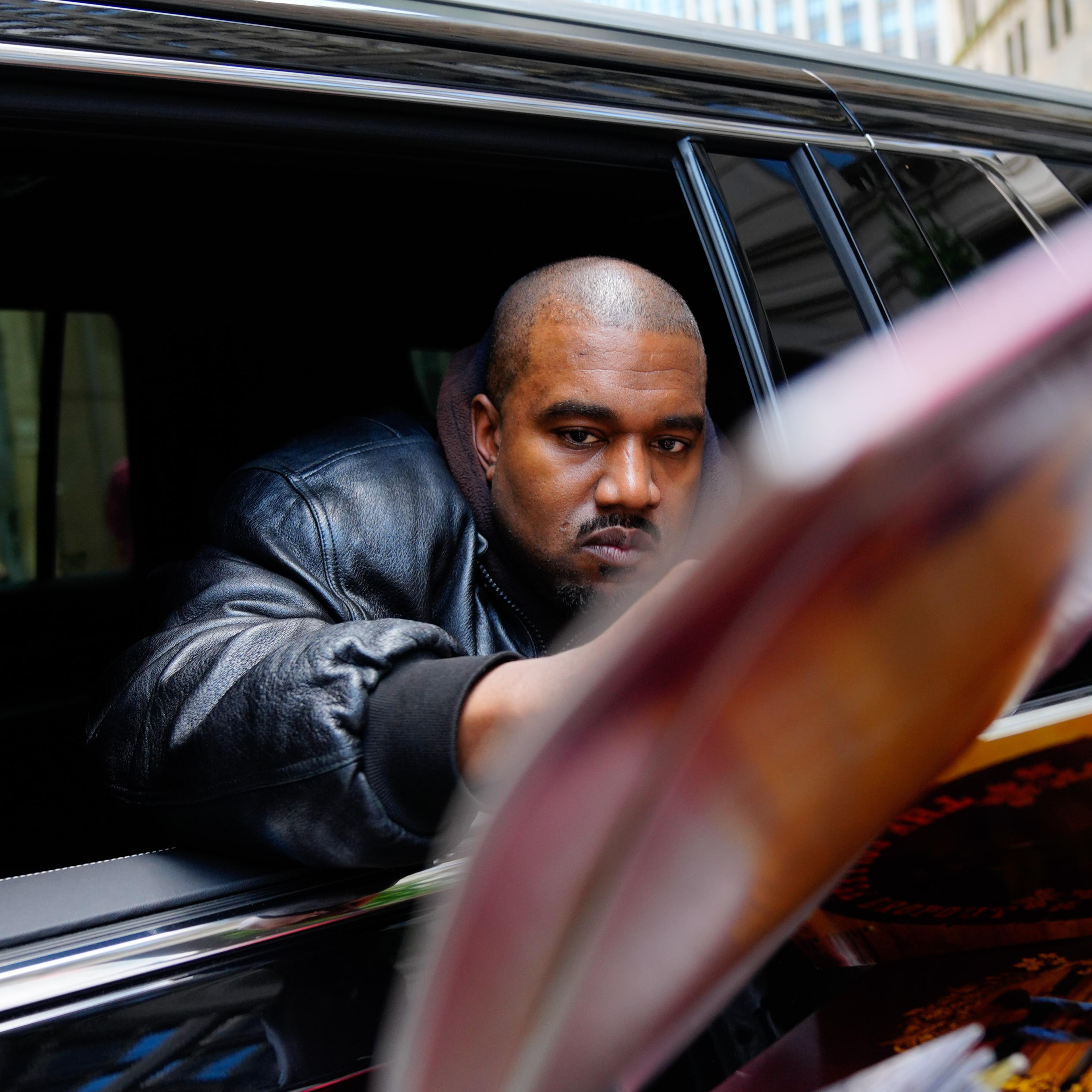 Kanye West signing albums out of a car window