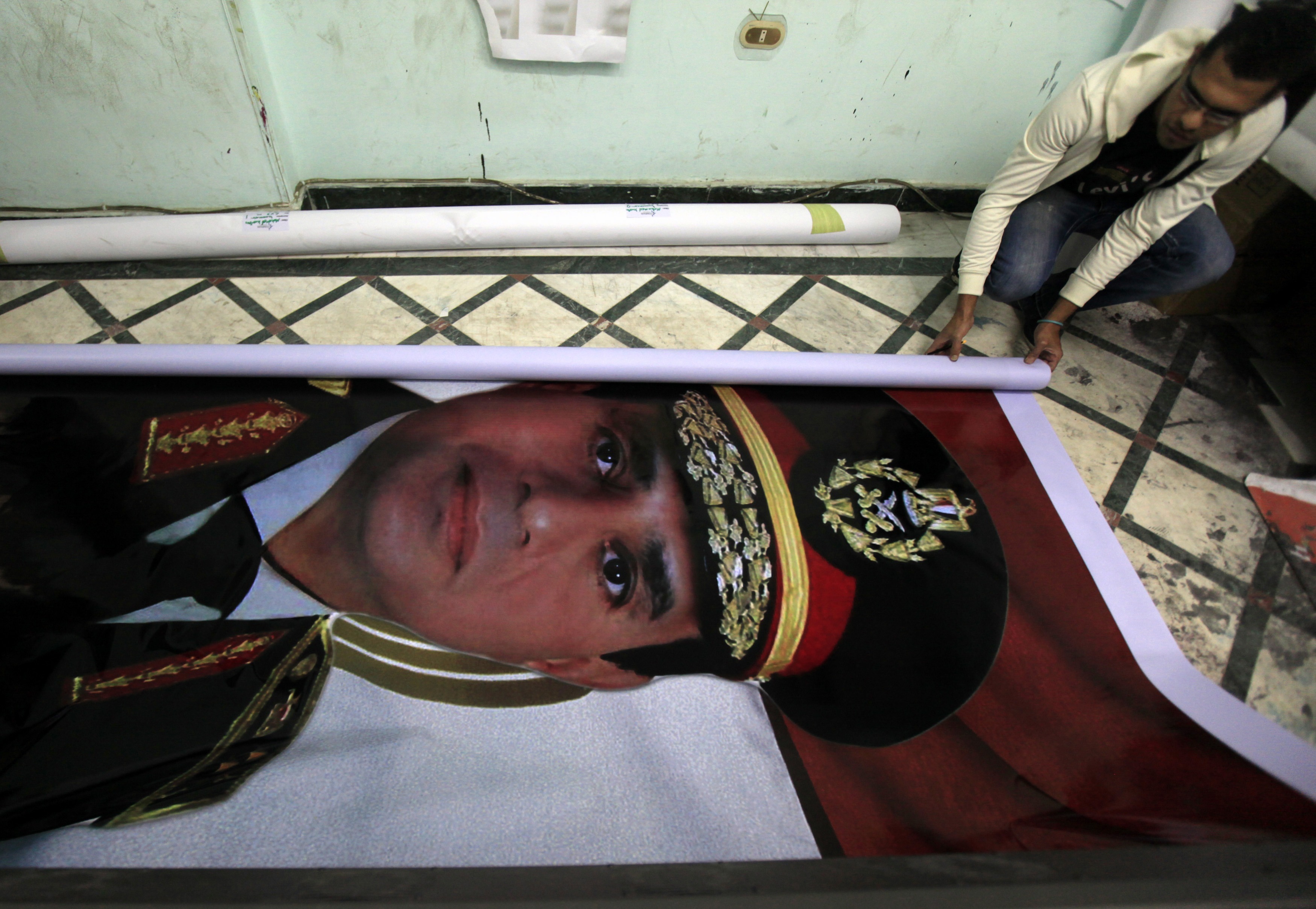 Eyes on the prize A printshop worker rolls up a poster of al-Sisi, who resigned as Egypts military chief in March in order to run for President