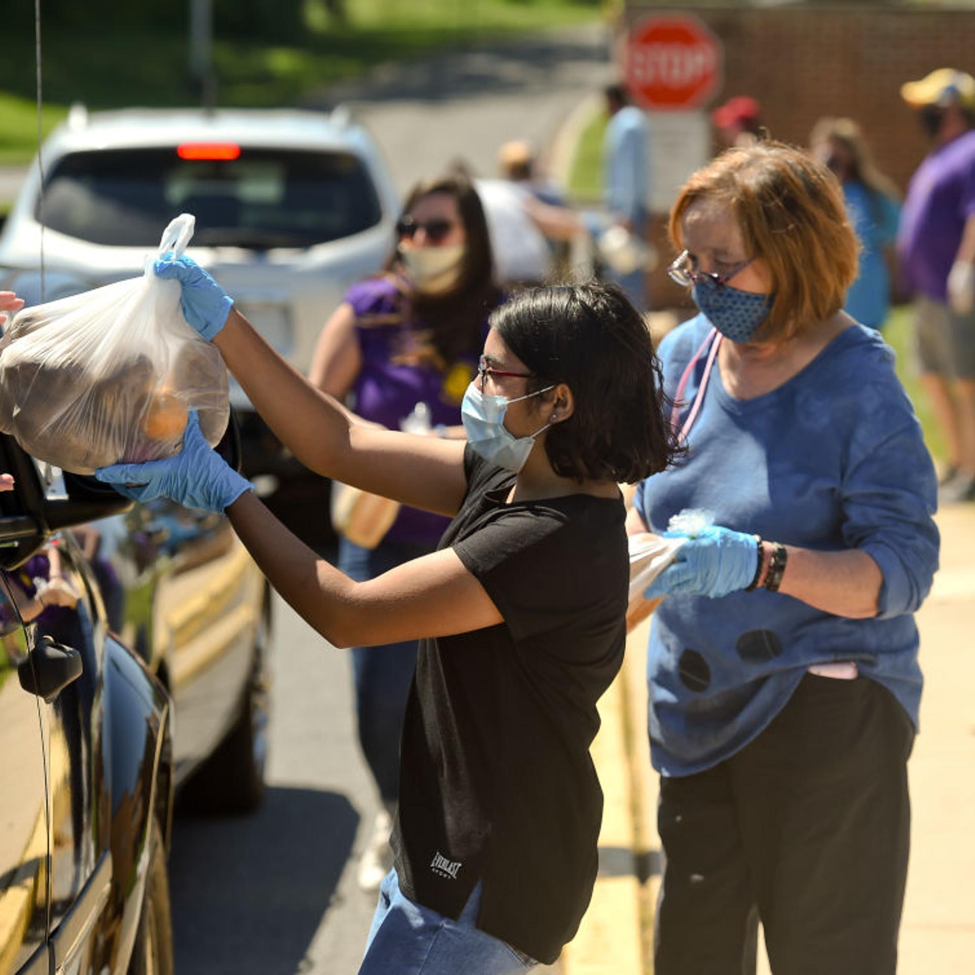 People receive bags of food at a drive-through food distribution event in Cumru, Penn. on May 30.