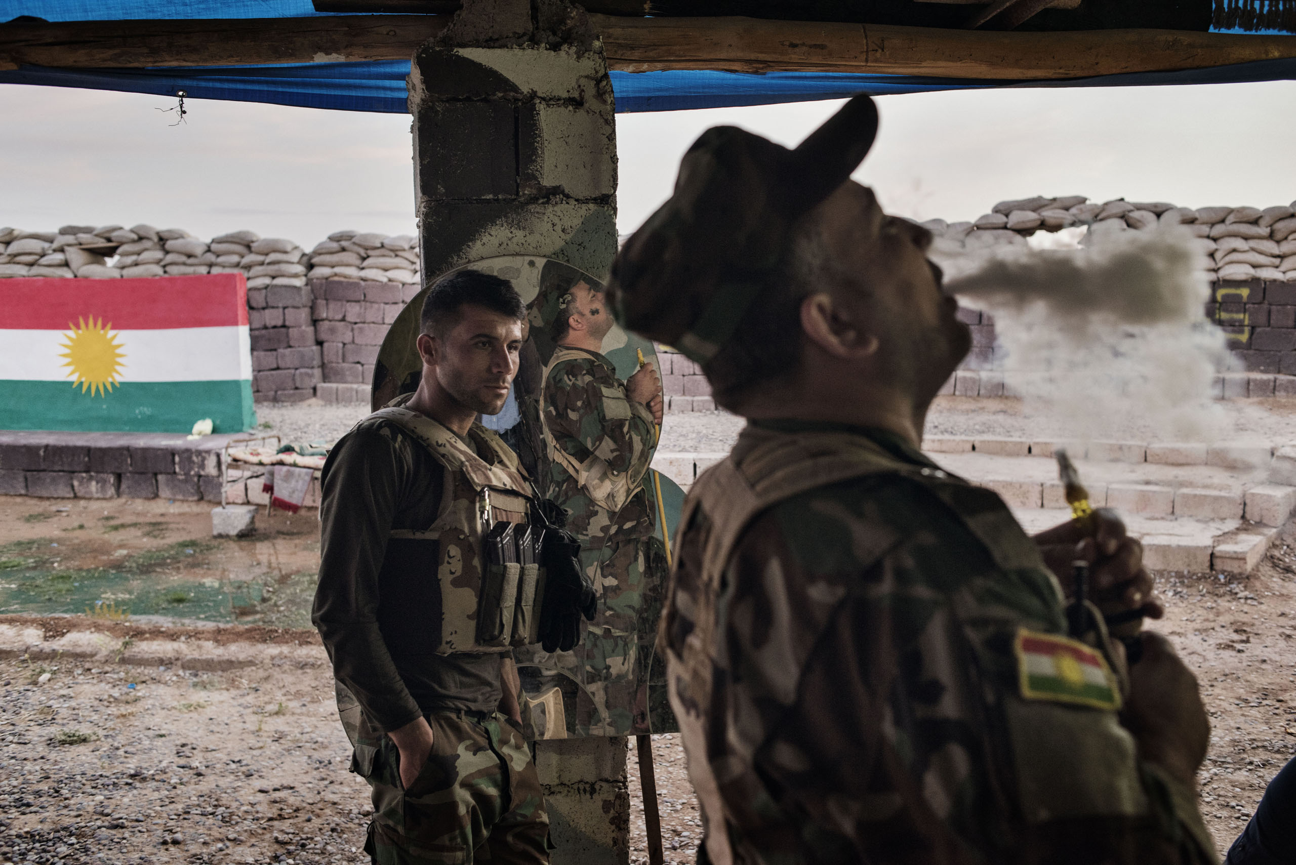 An Iraqi Kurdish fighter exhales tobacco smoke at the front line facing ISIS militants outside the town of Makhmour, northern Iraq, May 8, 2016. Makhmour is one of the key fronts in the battle between Iraqi forces and the jihadists of ISIS. But as a resu
