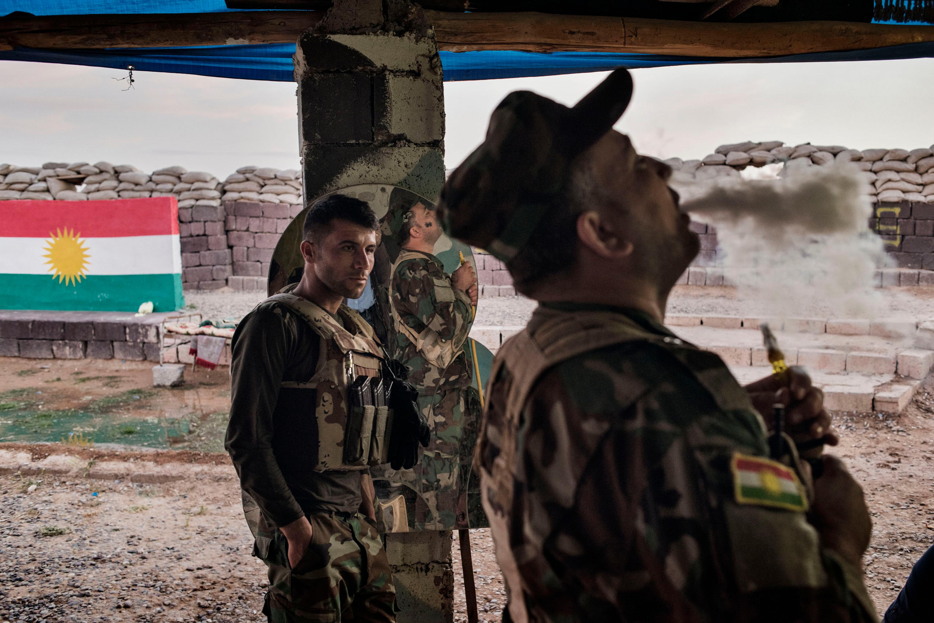 An Iraqi Kurdish fighter exhales tobacco smoke at the front line facing ISIS militants outside the town of Makhmour, northern Iraq, May 8, 2016. Makhmour is one of the key fronts in the battle between Iraqi forces and the jihadists of ISIS. But as a resu