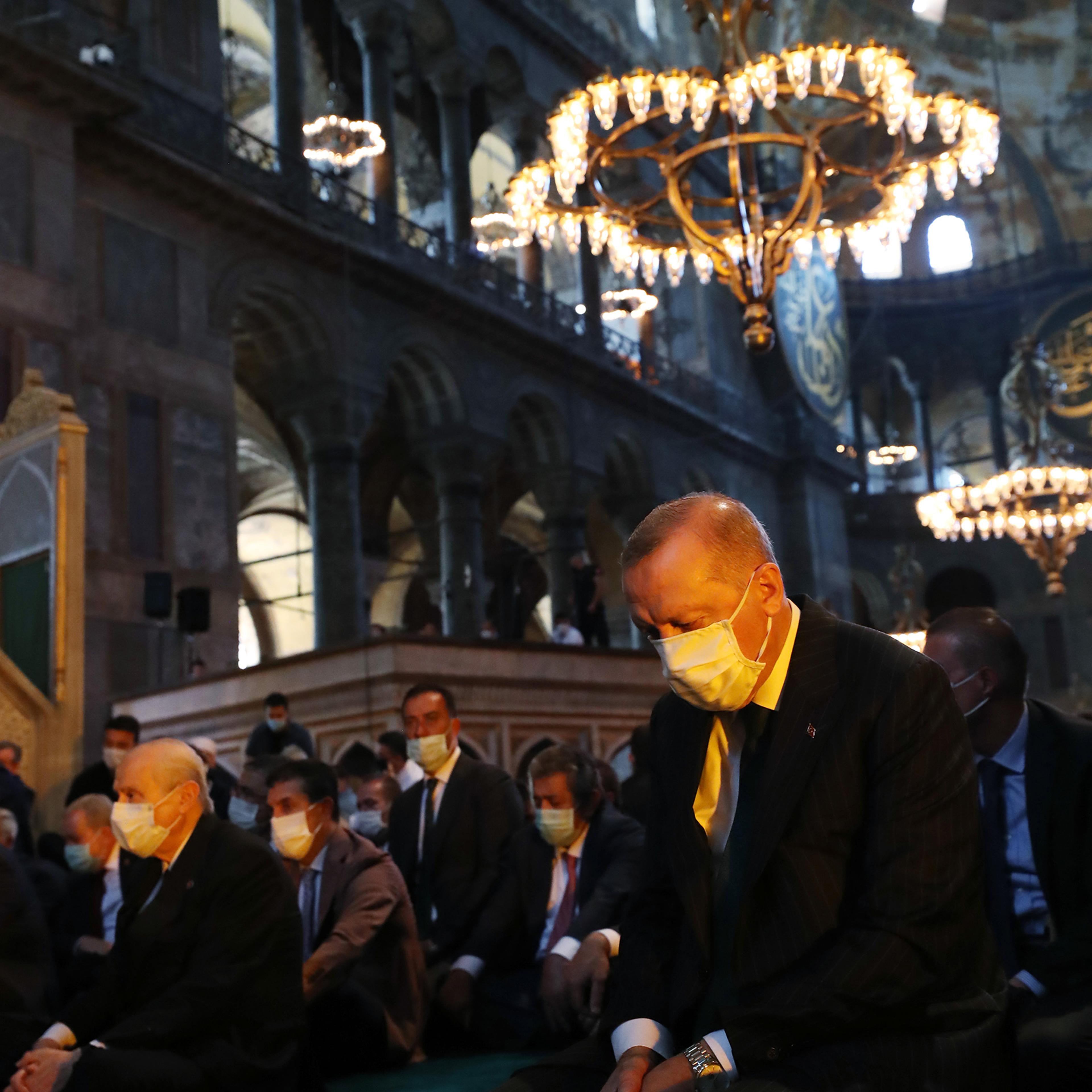Turkey's President Recep Tayyip Erdogan (C) and invited guests attend Friday prayers at Hagia Sophia during the first official prayers after being reconverted into a mosque on July 24