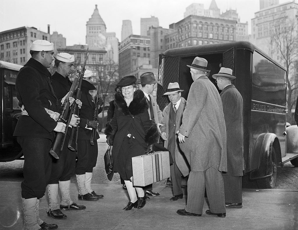 Coast Guardsmen stand guard as illegal migrants arrested by police and FBI agents, and are escorted out of a police van at the barge office in New York City on Dec.  9, 1941. They were later transferred to the immigration detention center on Ellis Island.