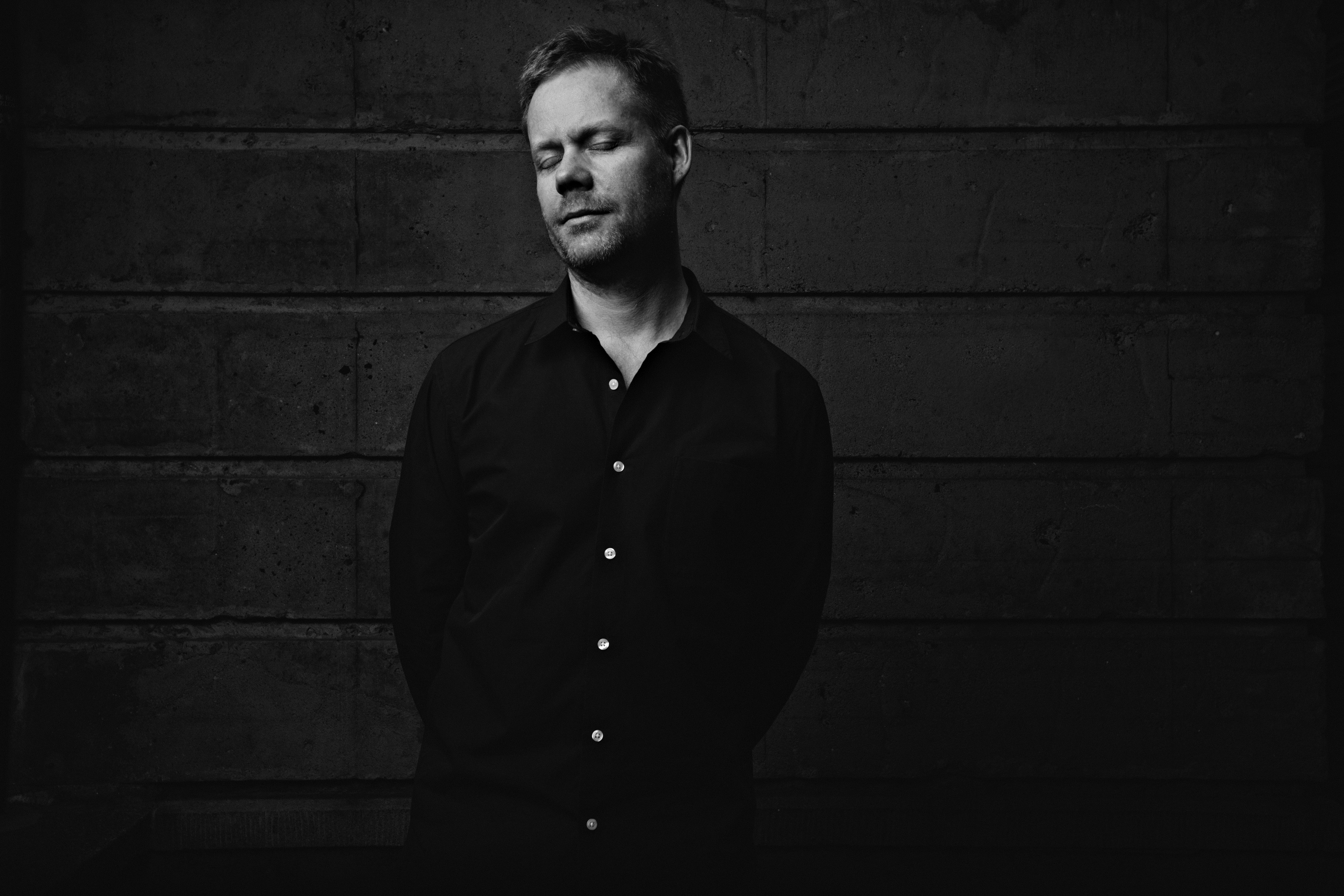 Max Richter, British composer, stands with his eyes closed.