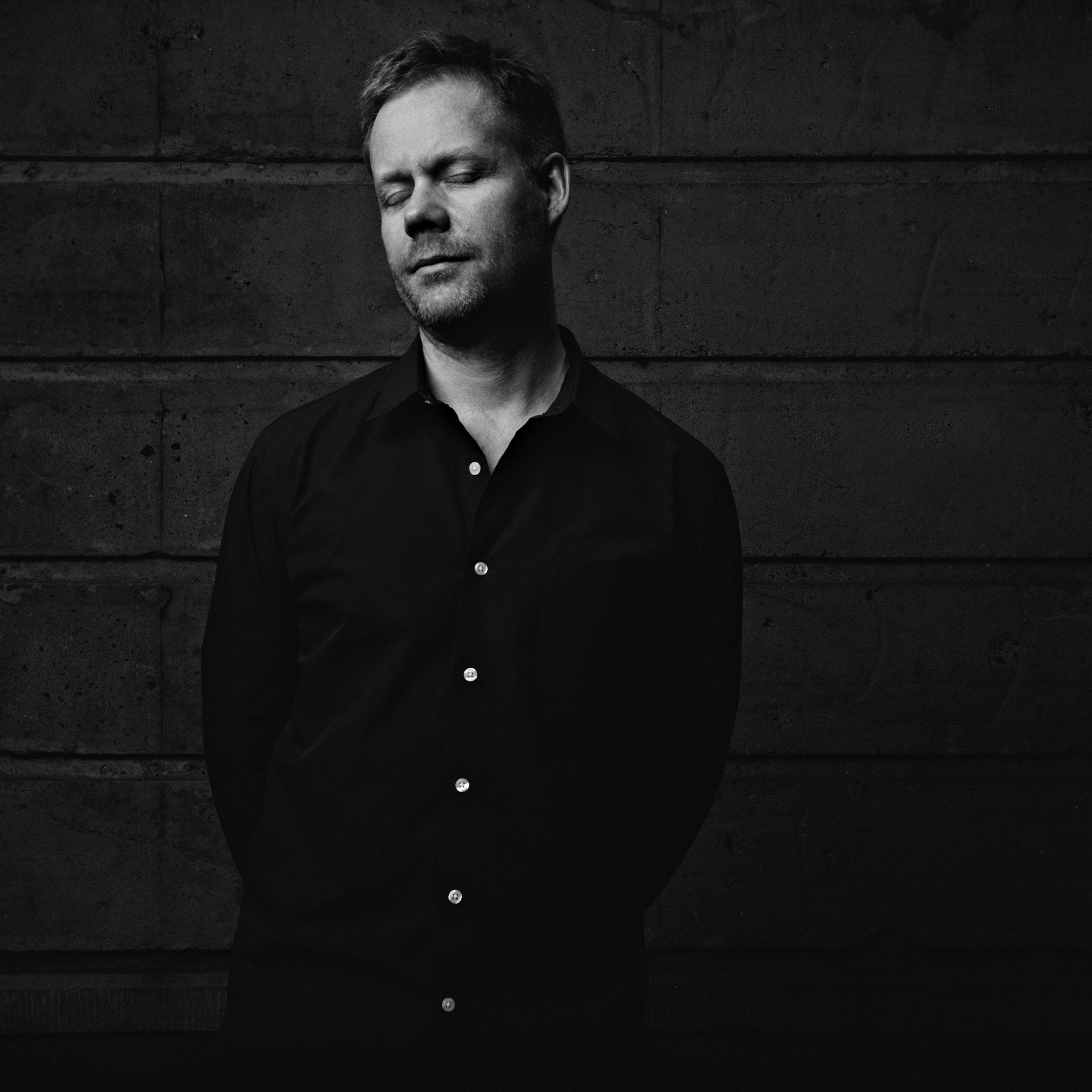 Max Richter, British composer, stands with his eyes closed.