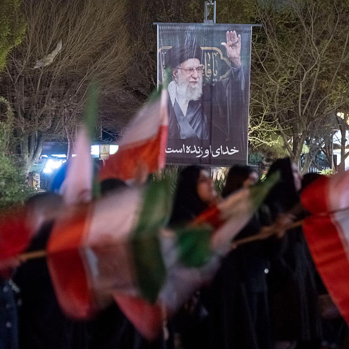 Iranian women wave national flags under a portrait of Iran's Supreme Leader Ayatollah Ali Khamenei while participating in a rally in Tehran, Iran, on March 1, 2026.