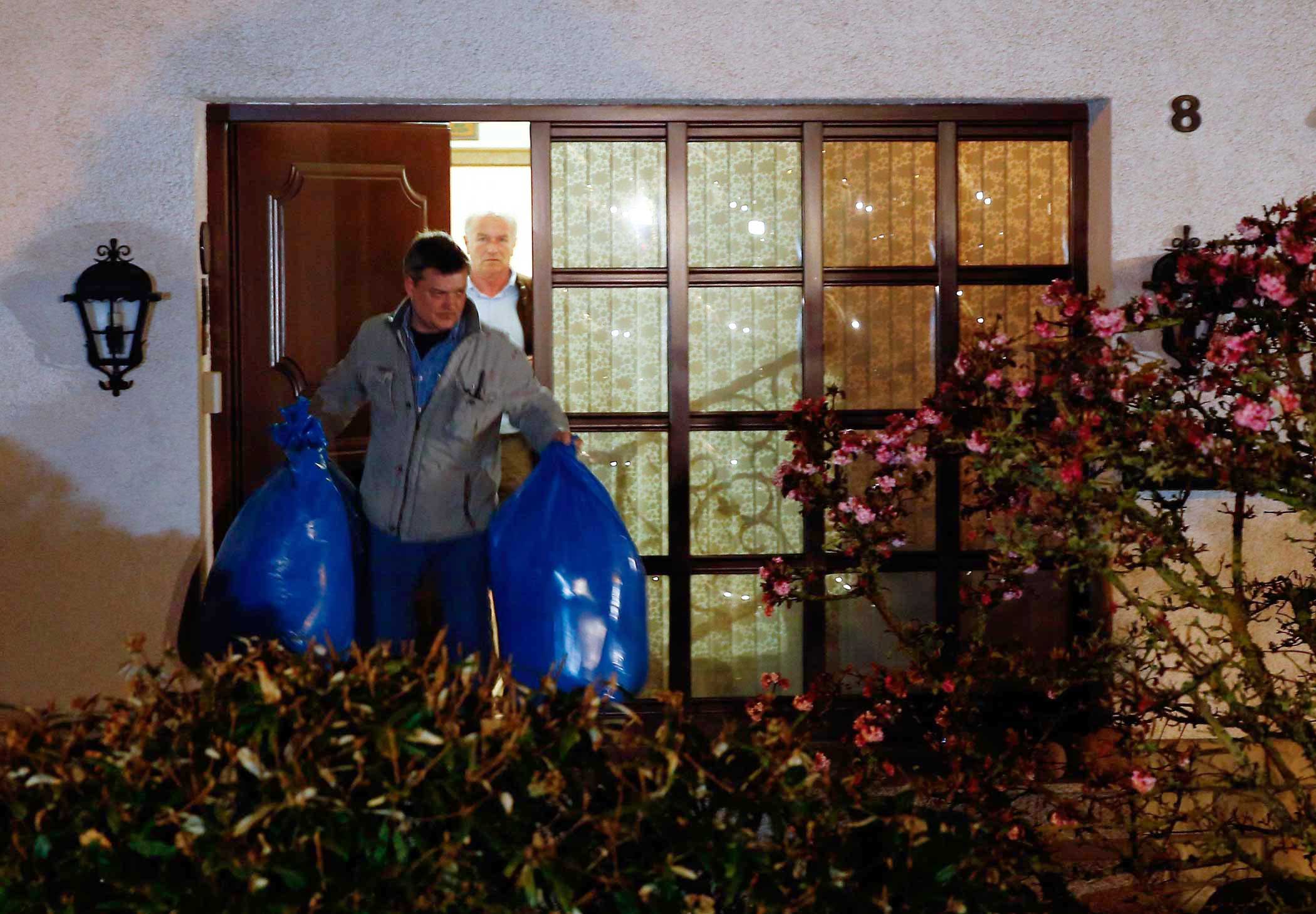 German police officers carry bags out of a house believed to belong to the parents of crashed Germanwings flight 4U 9524 co-pilot Andreas Lubitz in Montabaur on March 26, 2015.