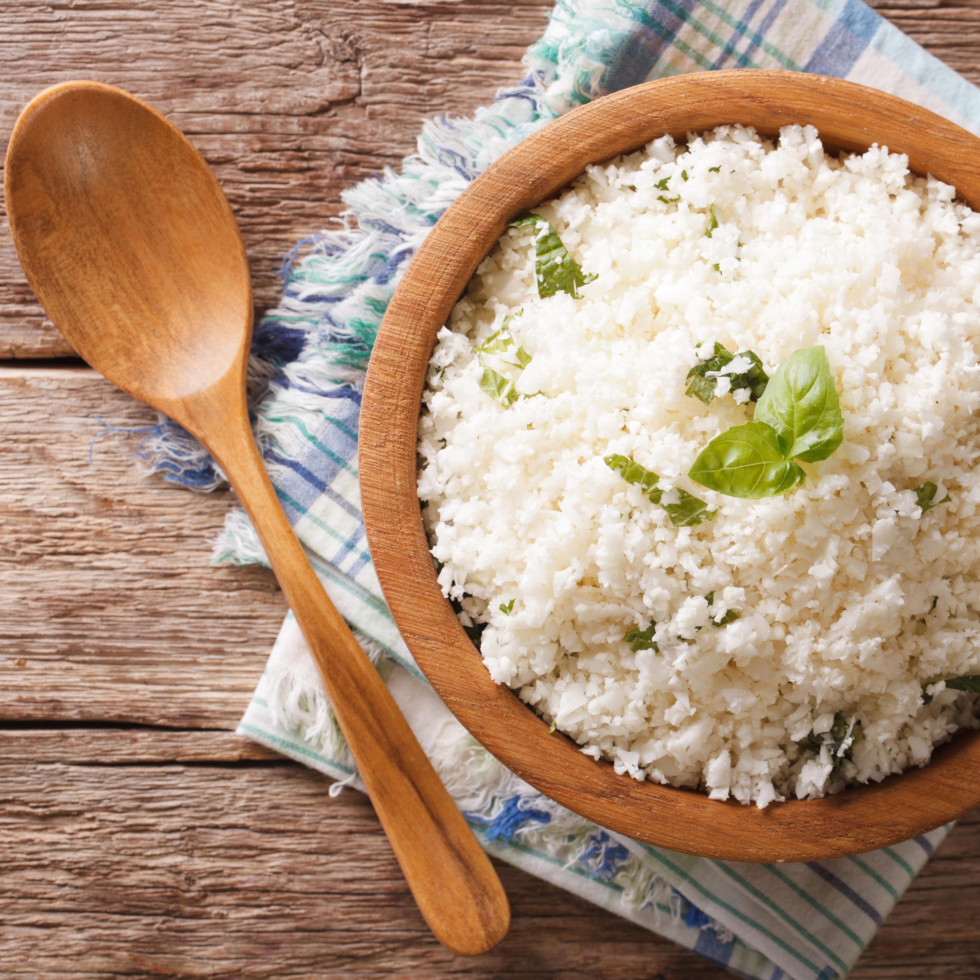 Cauliflower rice with basil in bowl close-up. Horizontal top view