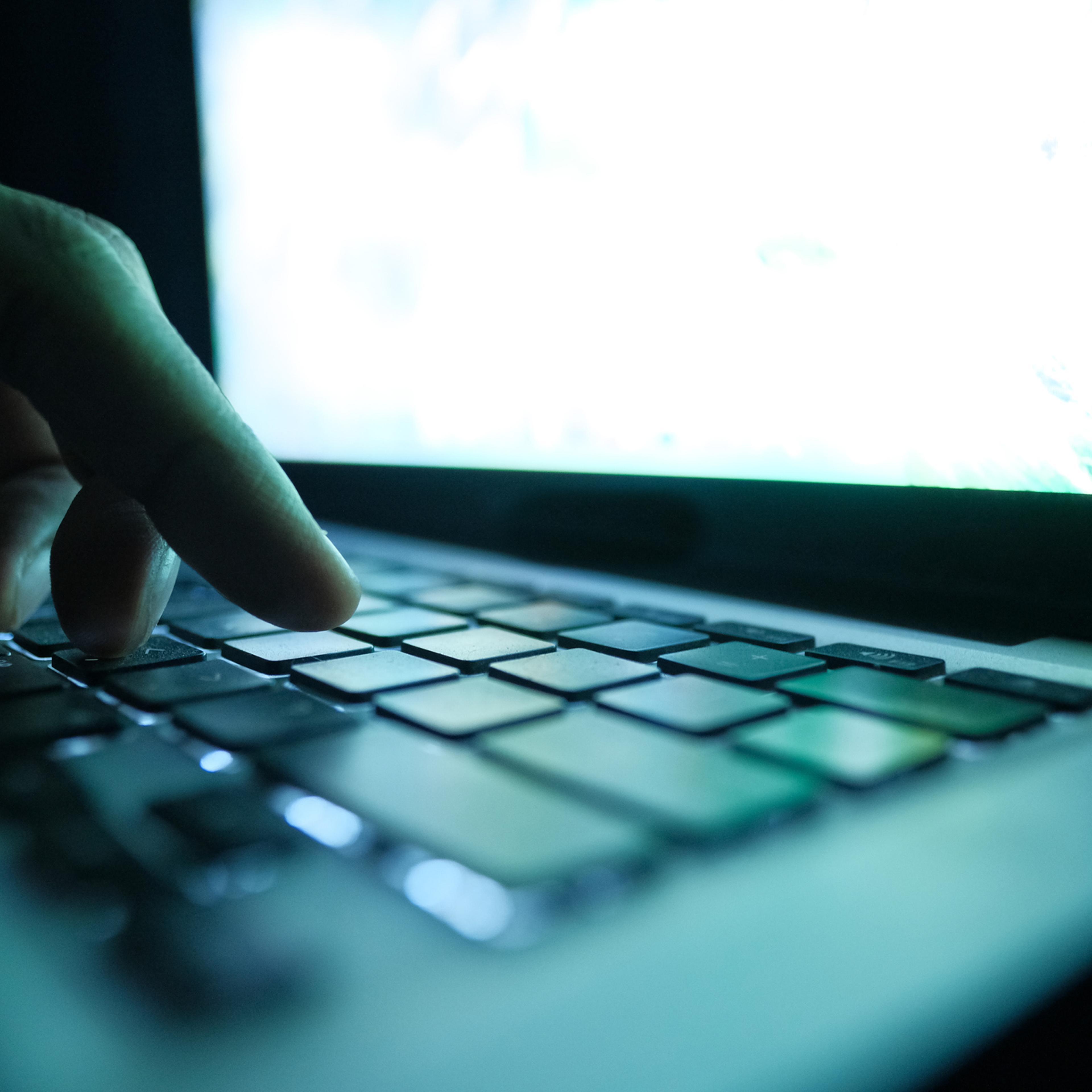 close up of hacker hand typing code