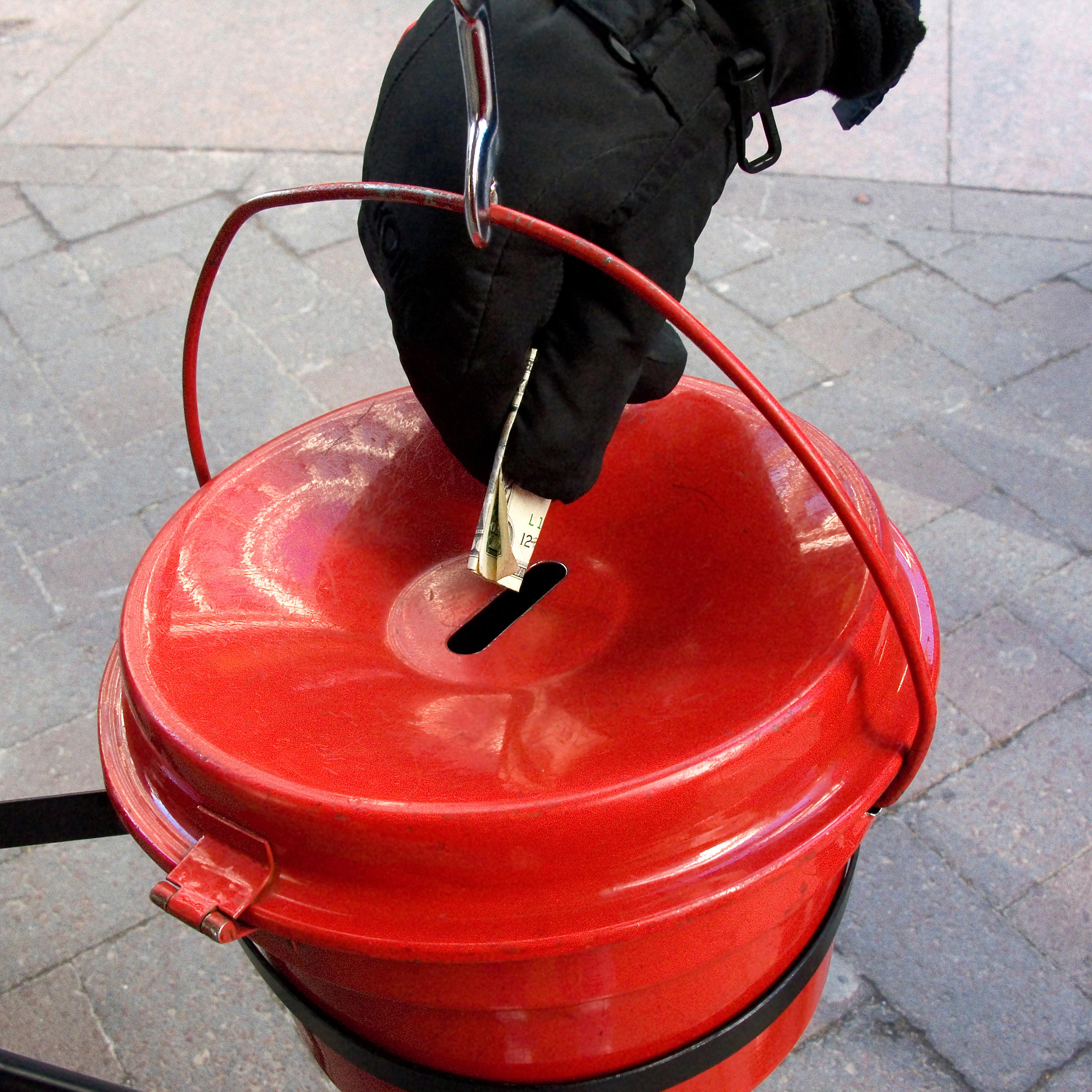 Person putting money into a Salvation Army kettle.