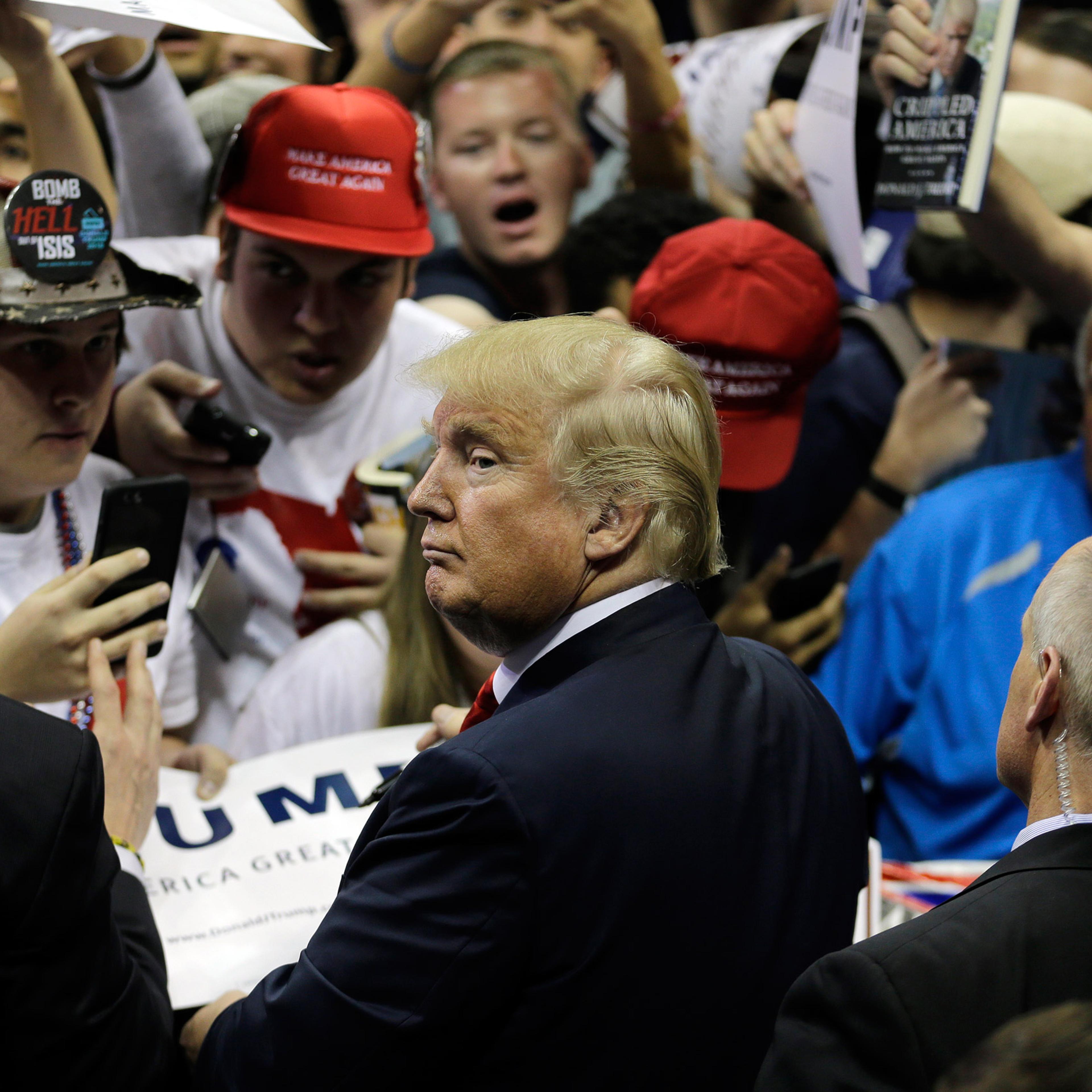 Republican presidential candidate Donald Trump signs autographs during a rally Friday, Feb. 12, 2016, in Tampa, Fla. (AP Photo/Chris O'Meara)