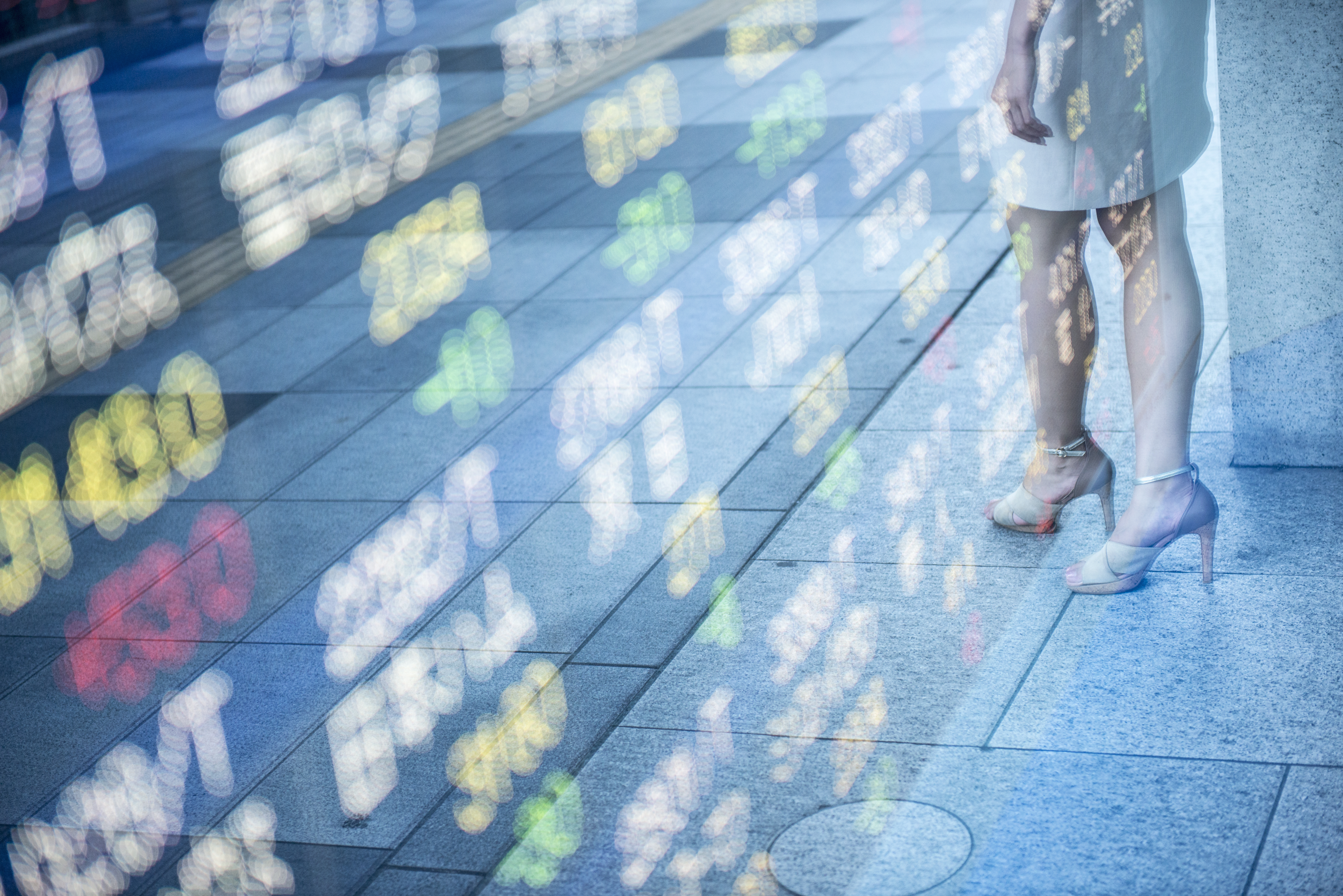 Stock readings on window and reflection of female.