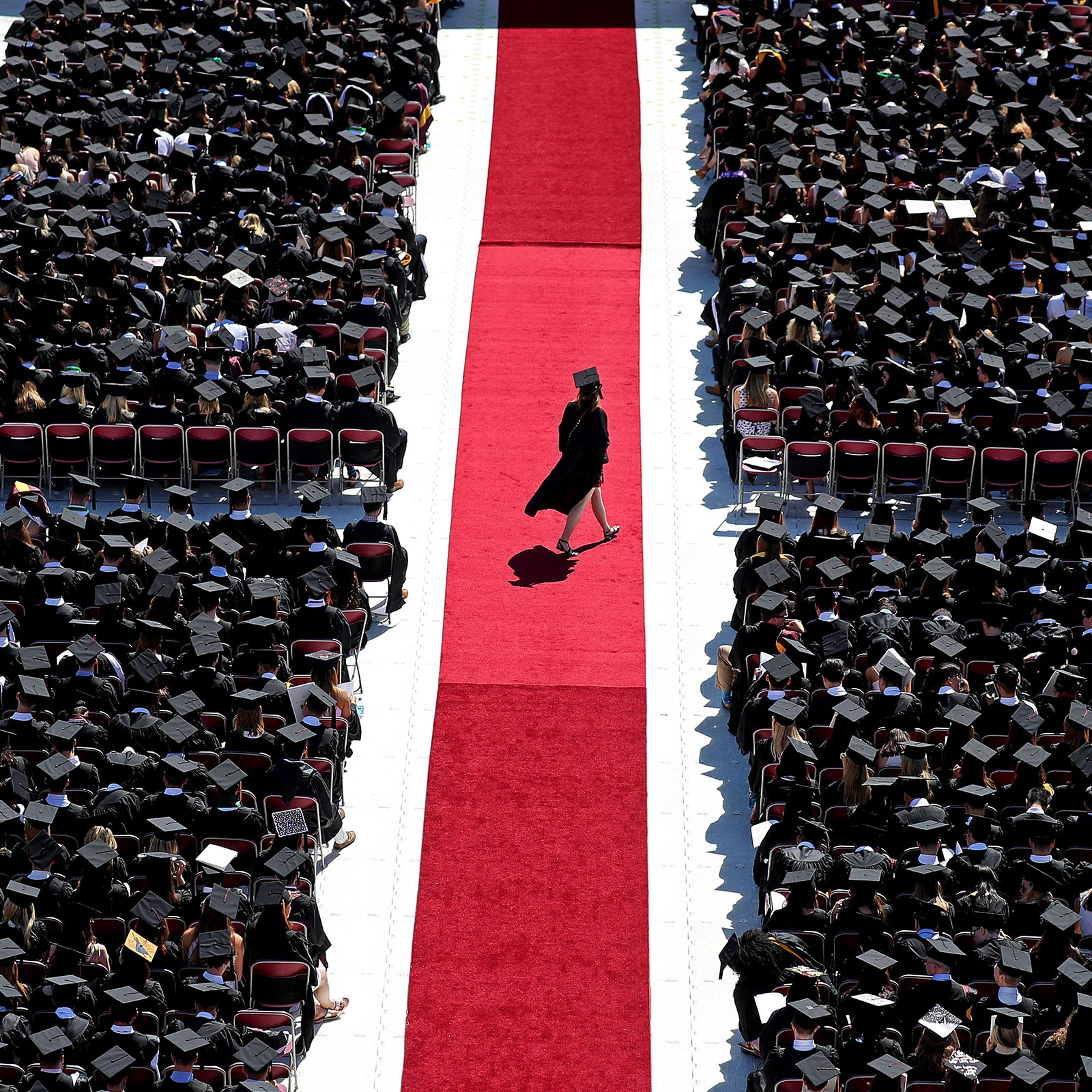 A graduate crosses the red carpet at Boston College’s commencement on May 21, 2018