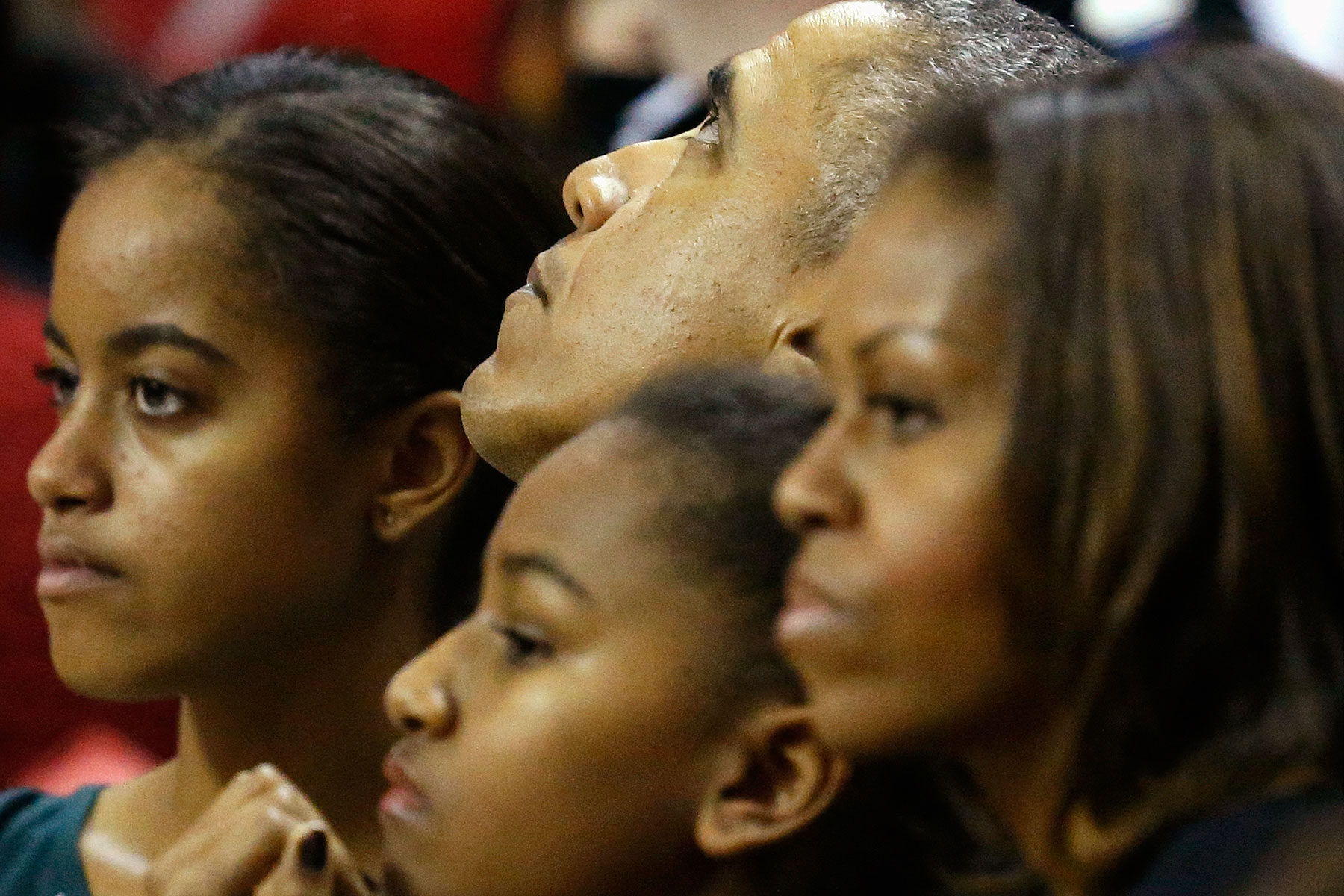 U.S. President Barack Obama, his daughters Malia and Sasha, and first lady Michelle watch an NCAA men's basketball game between Oregon State and the University of Maryland at College Park, Maryland, November 17, 2013