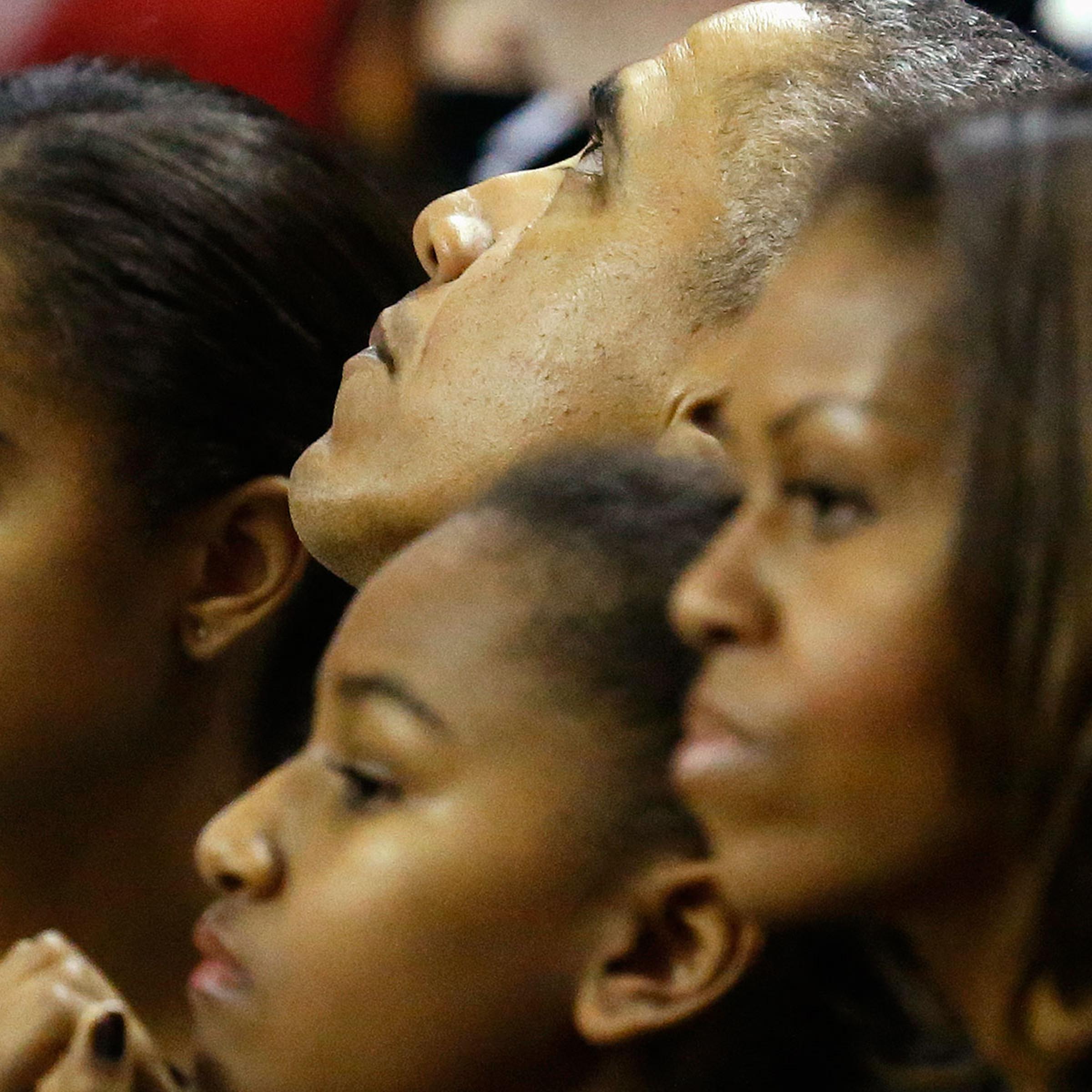U.S. President Barack Obama, his daughters Malia and Sasha, and first lady Michelle watch an NCAA men's basketball game between Oregon State and the University of Maryland at College Park, Maryland, November 17, 2013