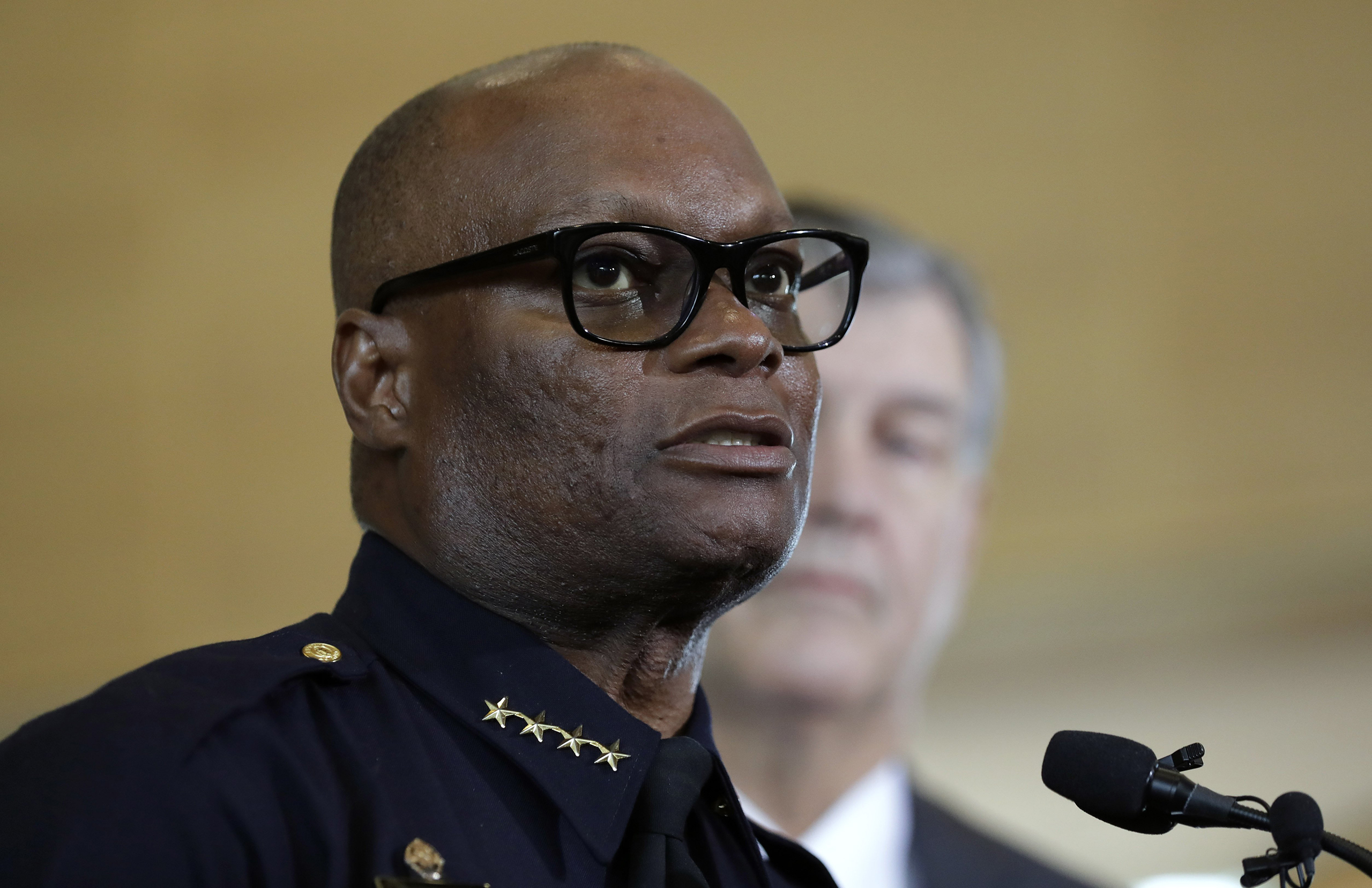 Dallas police chief David Brown, front, and Dallas mayor Mike Rawlings, rear, talk with the media during a news conference in Dallas, July 8, 2016.