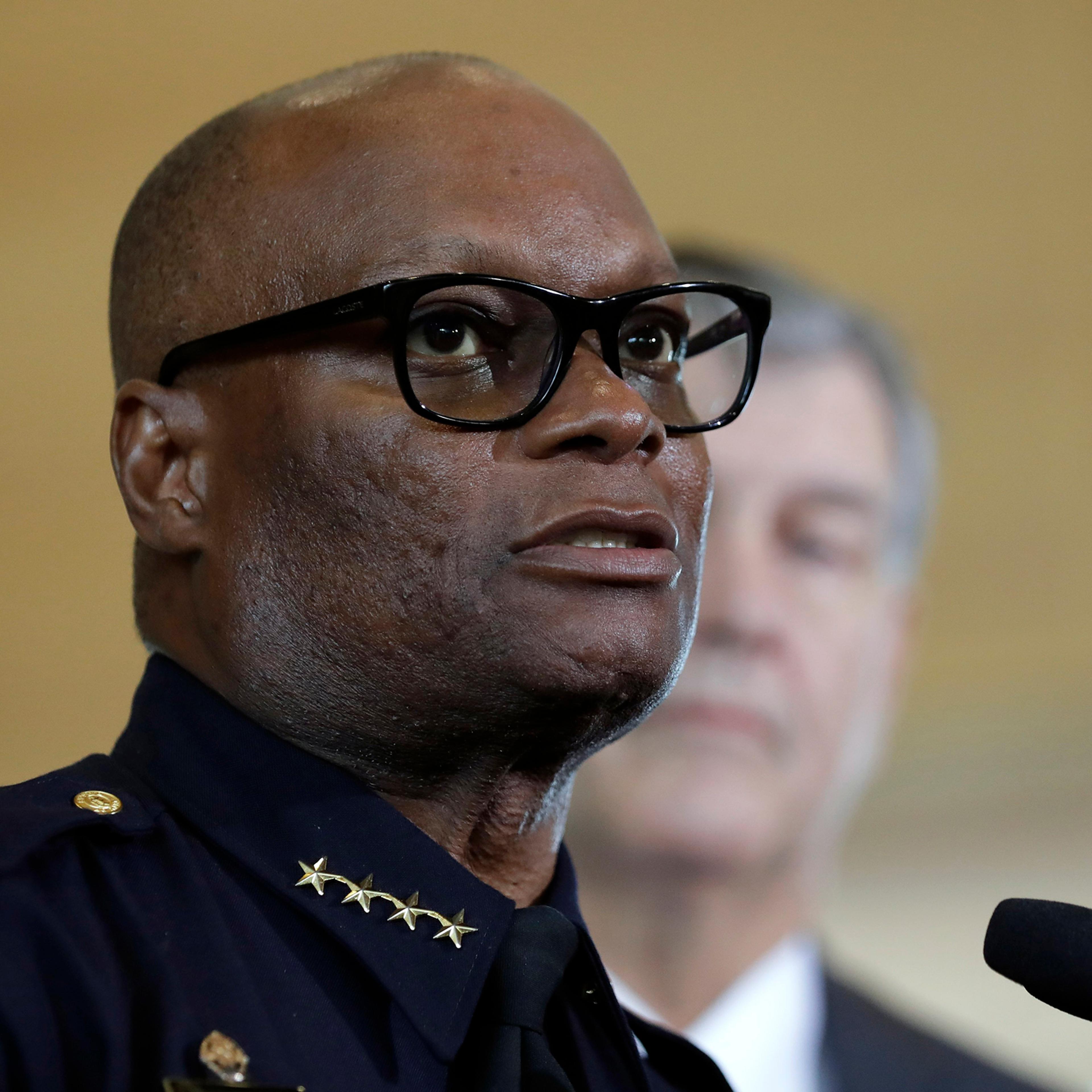 Dallas police chief David Brown, front, and Dallas mayor Mike Rawlings, rear, talk with the media during a news conference in Dallas, July 8, 2016.