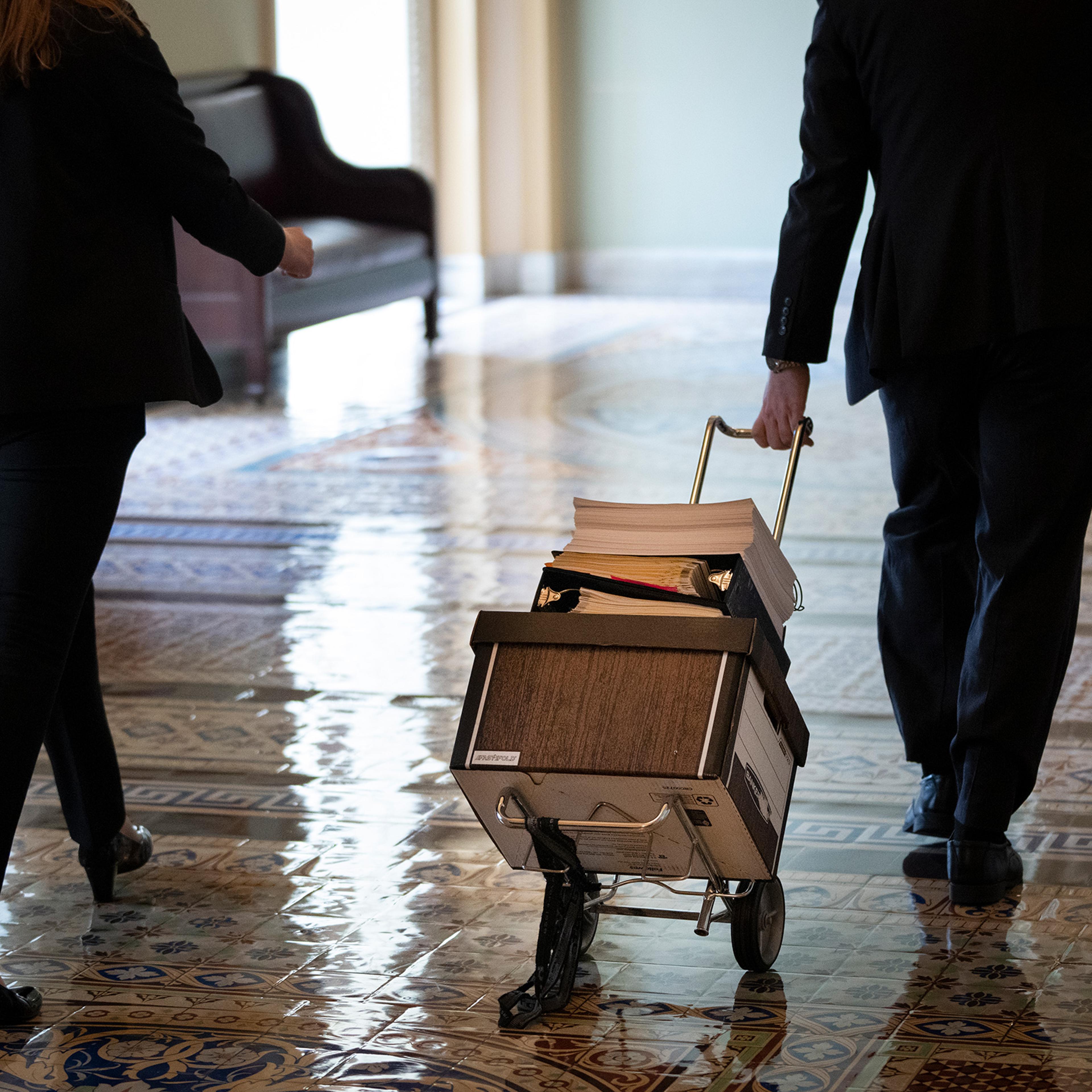 Documents, including text of the bipartisan infrastructure legislation, is wheeled toward the office of Senate Majority Leader Chuck Schumer at the Capitol in Washington, D.C, on Aug. 2, 2021.