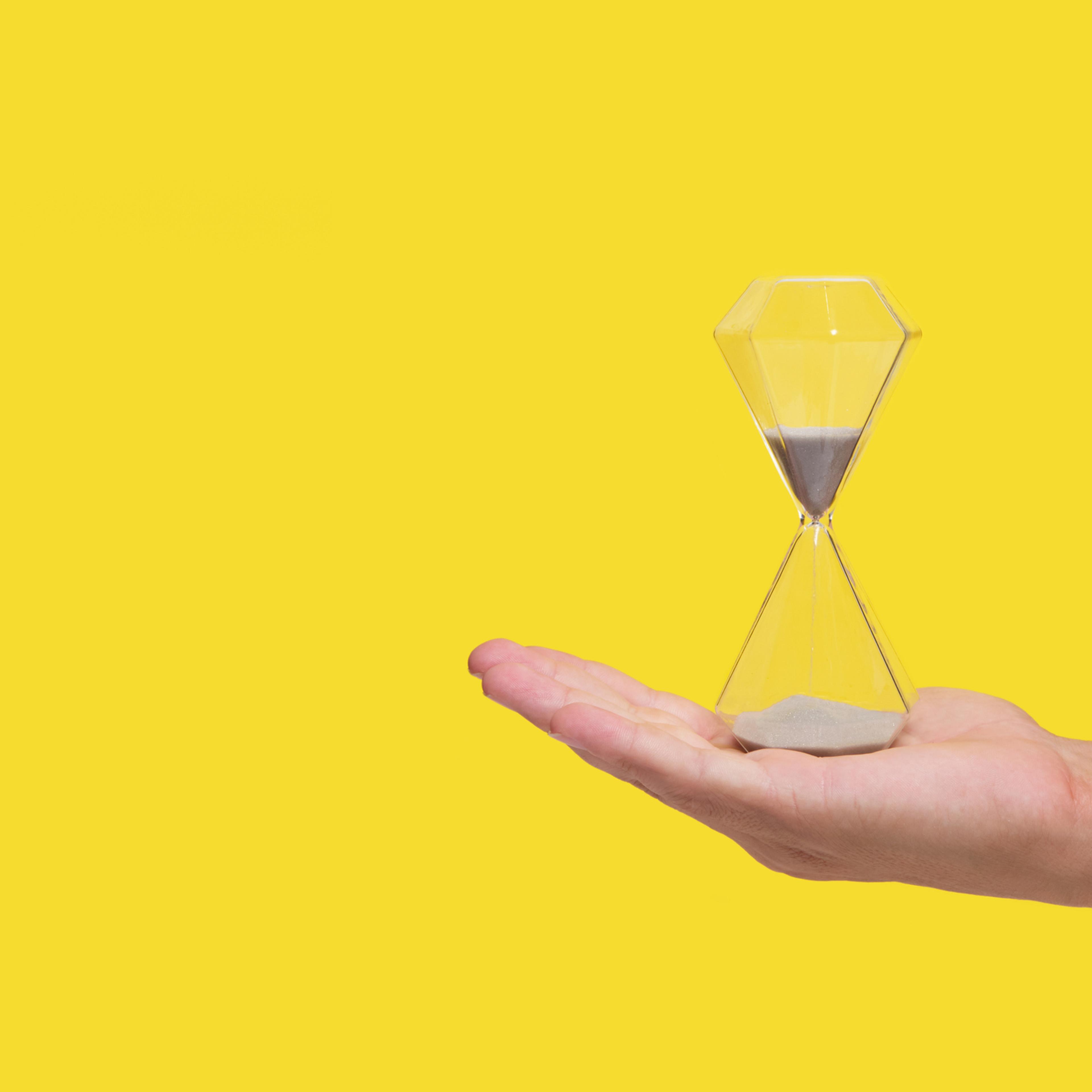 An hourglass on a man's palm
