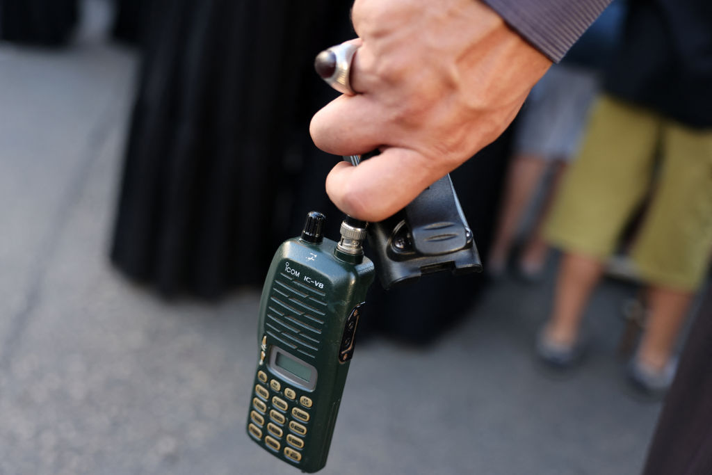 A man holds a walkie-talkie during the funeral of people killed in the explosions of pagers across Lebanon, in Beirut's southern suburbs, on Sept. 18, 2024.