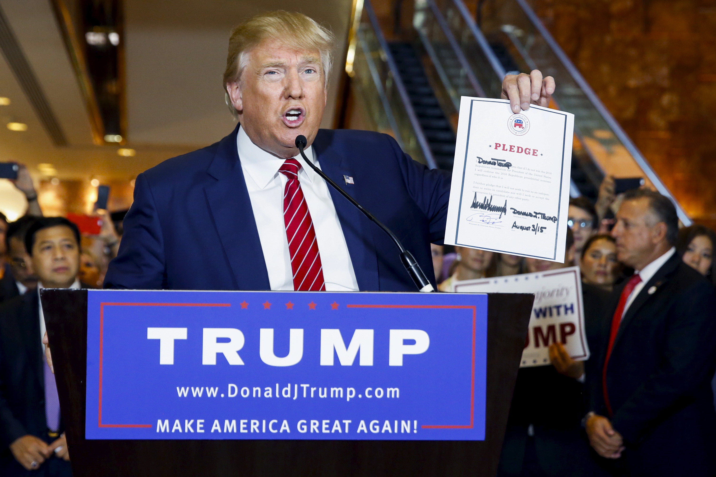 Presidential hopeful Donald Trump holds up a signed pledge during a press availability at Trump Tower in Manhattan on Sept. 3, 2015.