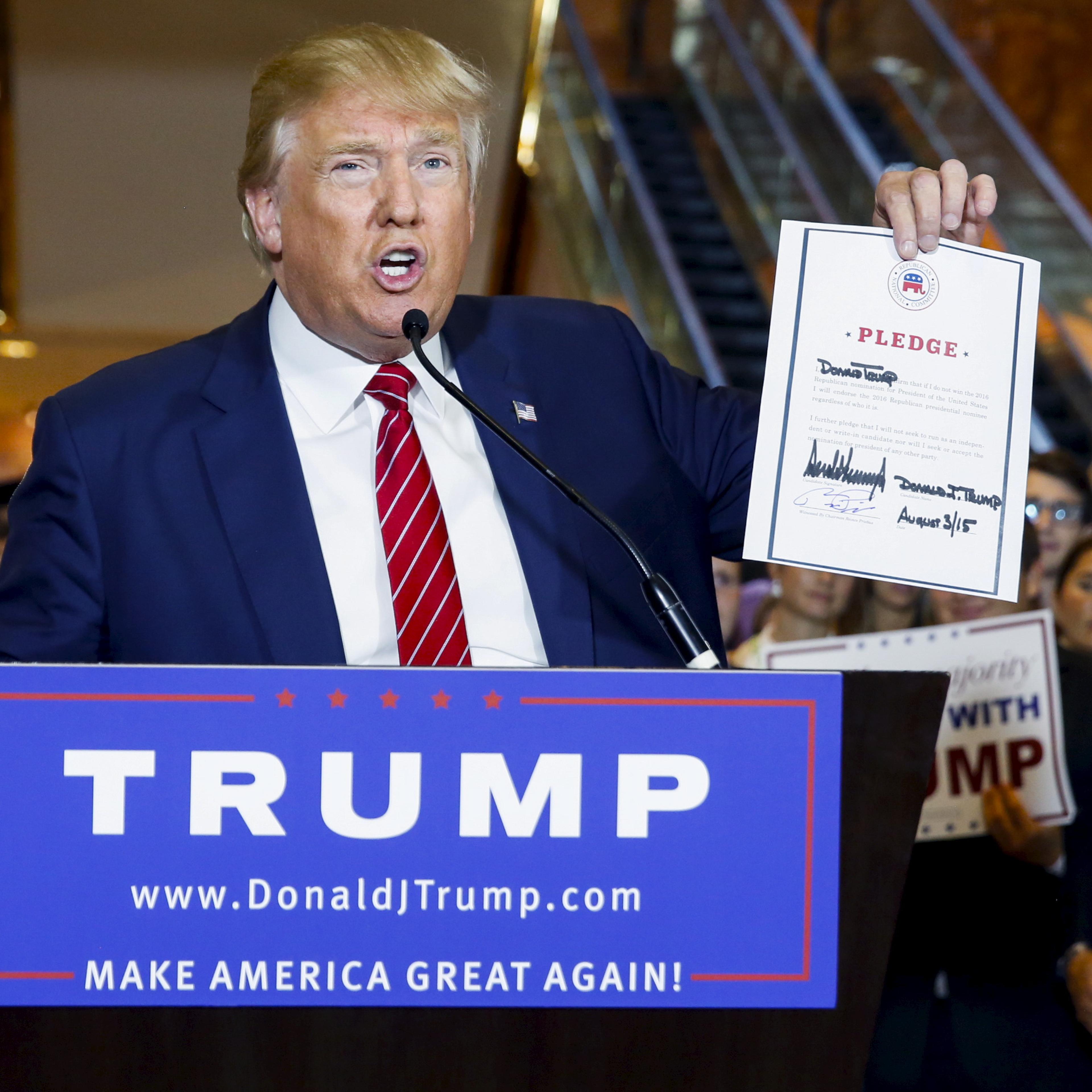 Presidential hopeful Donald Trump holds up a signed pledge during a press availability at Trump Tower in Manhattan on Sept. 3, 2015.