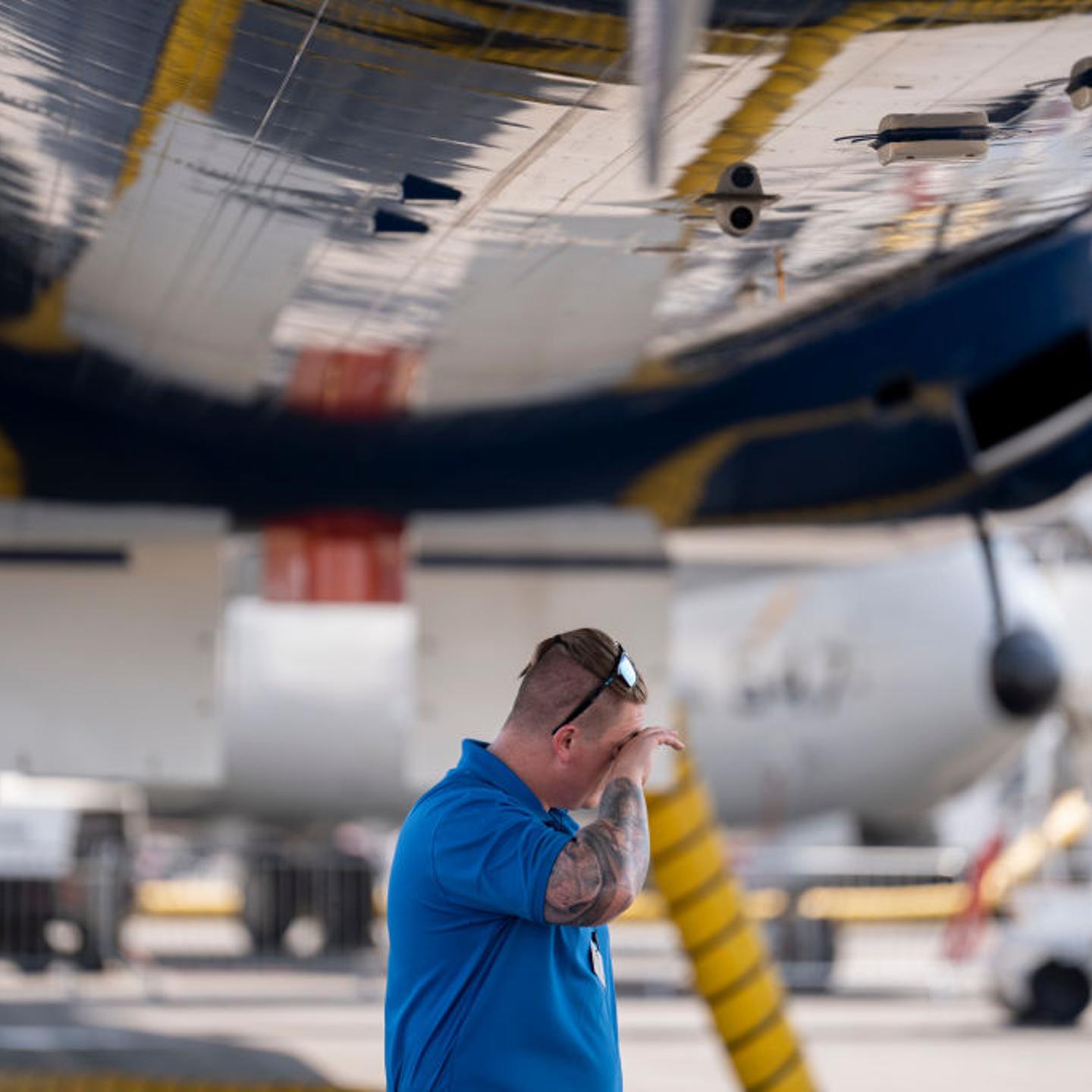 A Boeing employee stands in the shade during the UK heat wave 18th July 18 2022, at Farnborough, England.