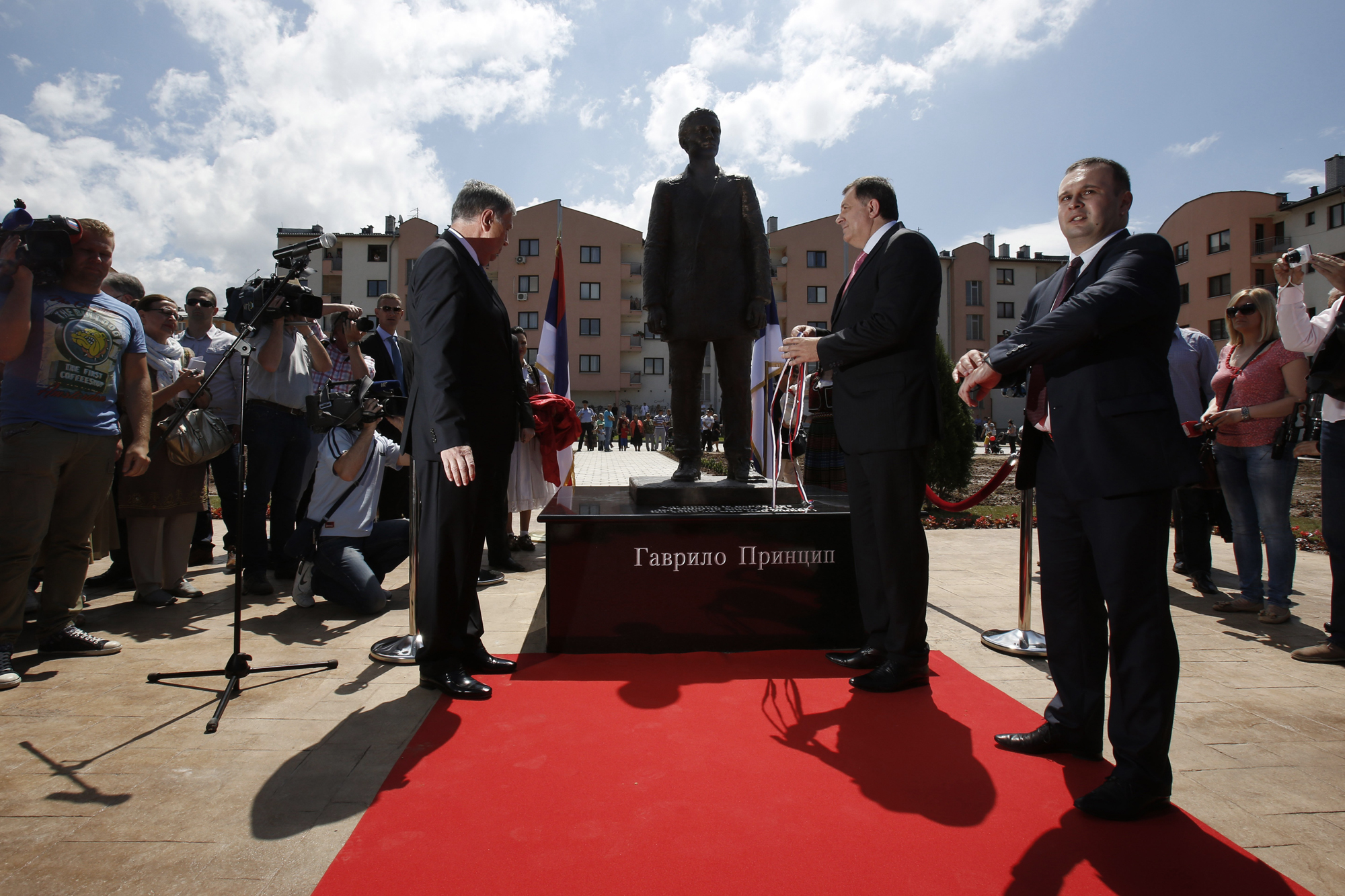 Member of Bosnian Tripartite Presidency Nebojsa Radmanovic, left, President of Republika Srpska Milorad Dodik , center, and local mayor Ljubisa Cosic, right, uncover a statue of Gavrilo Princip during ceremony of unveiling in Istocno Sarajevo, June 27, 2