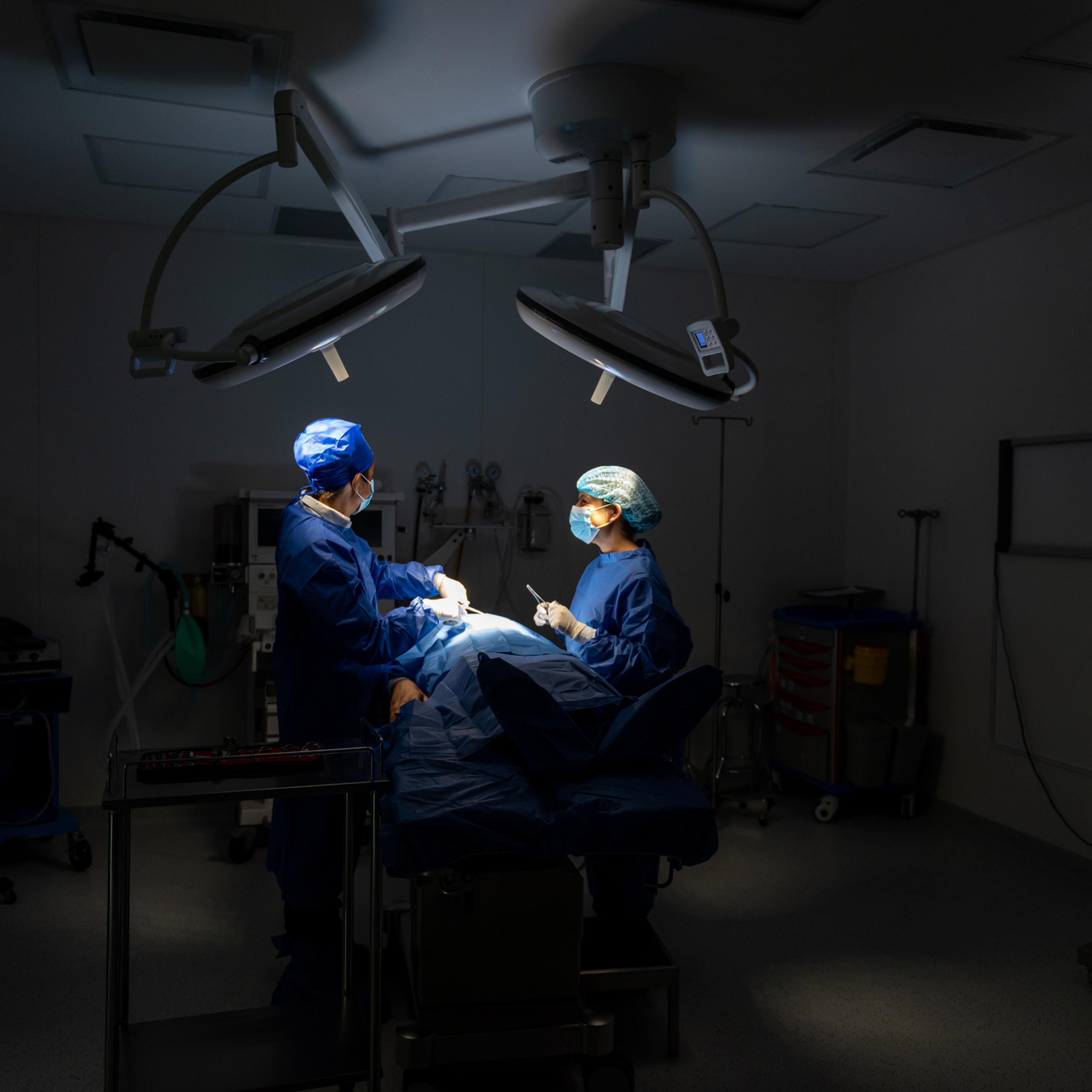 Doctors in surgery with patient in operating room.