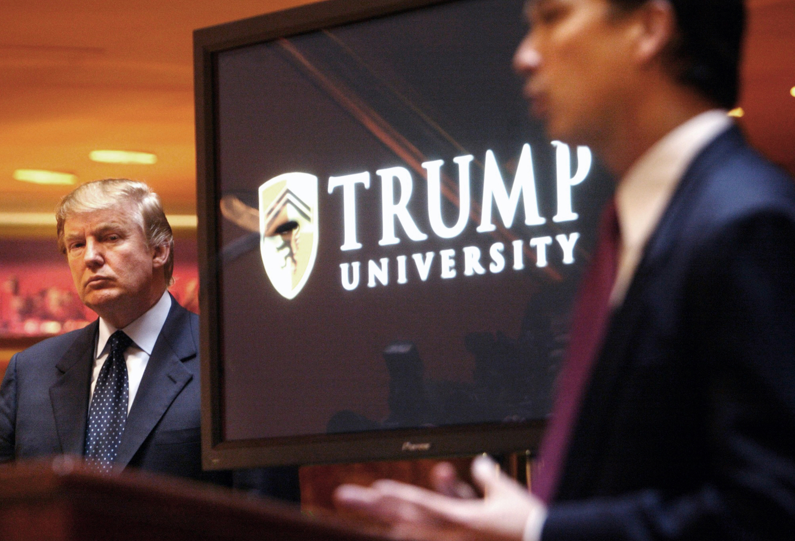 FILE- In this May 23, 2005, file photo, real estate mogul and Reality TV star Donald Trump, left, listens as Michael Sexton introduces him at a news conference in New York where he announced the establishment of Trump University. Tarla Makaeff a yoga ins