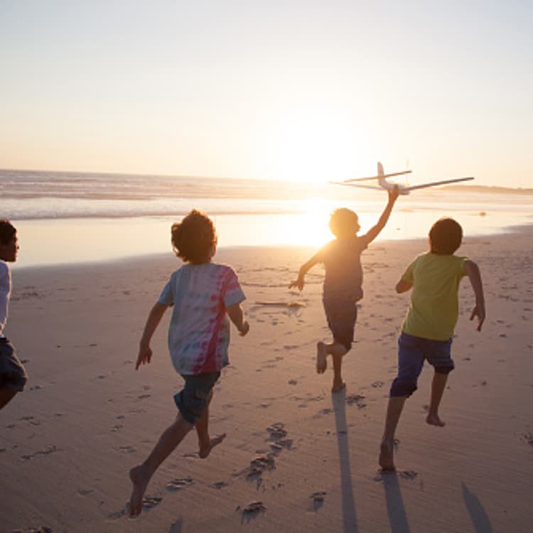 boys-running-beach-toy-plane