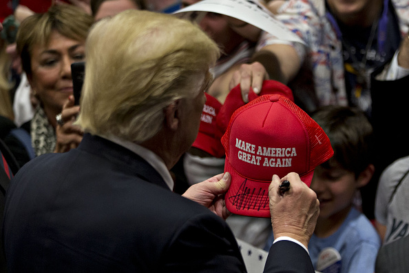 Donald Trump, president and chief executive of Trump Organization Inc. and 2016 Republican presidential candidate, signs a campaign hat after speaking during a campaign rally at West Chester University in West Chester, Pennsylvania, U.S., on Monday, Apri