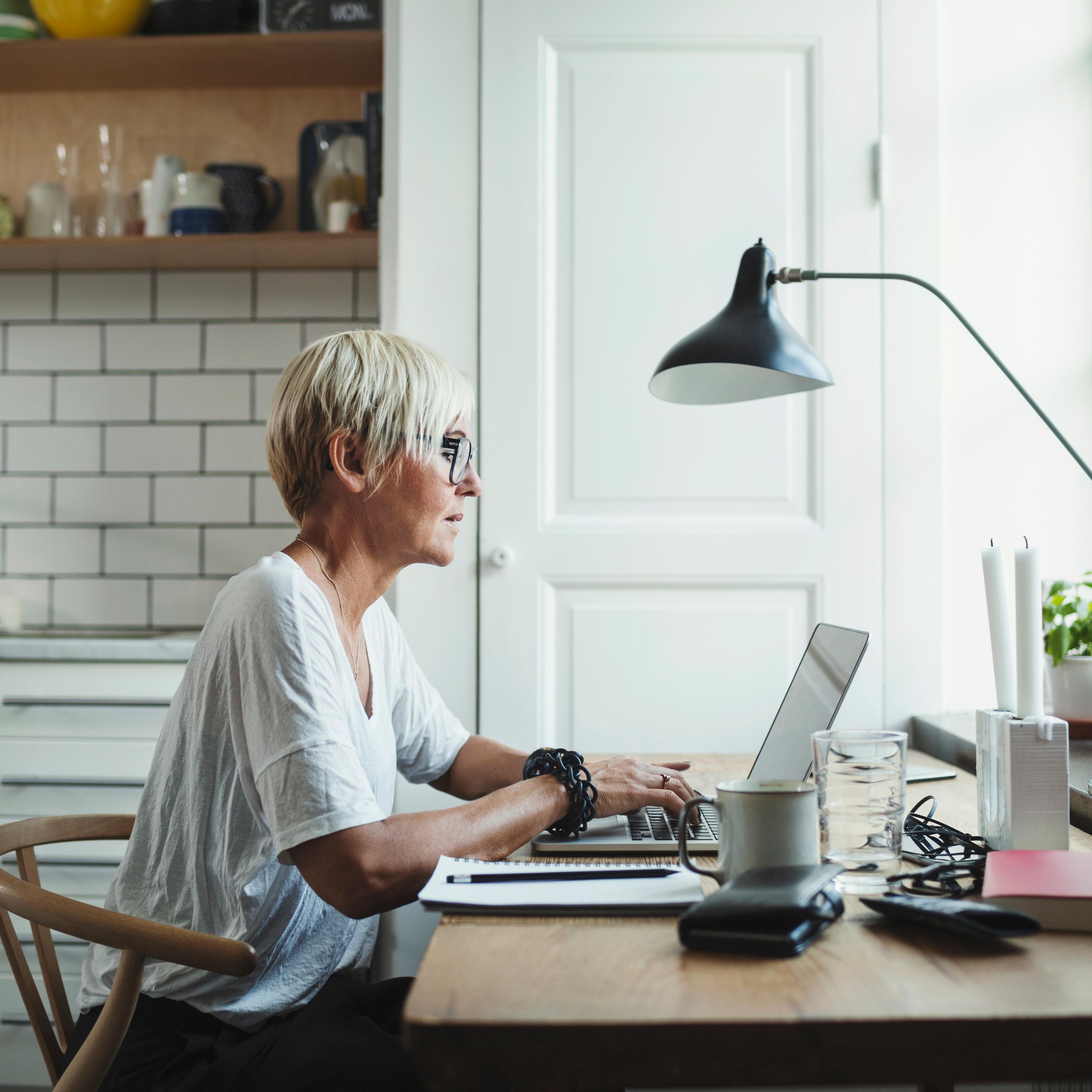 Side view of designer using laptop at home office