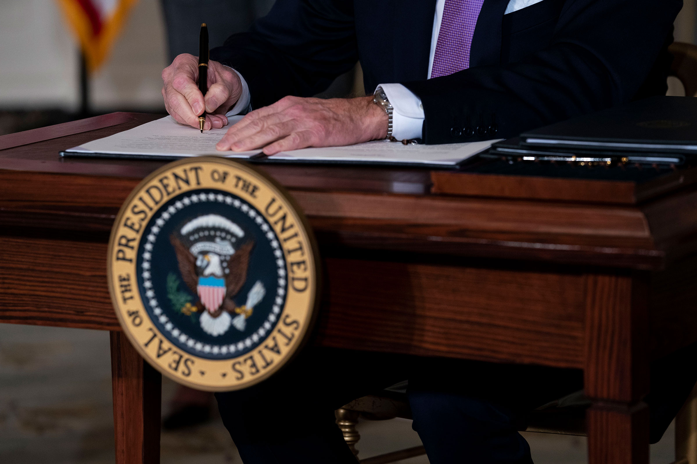 President Joe Biden signs the last of a series of executive actions during a ceremony at the White House in Washington on Jan. 26, 2021.