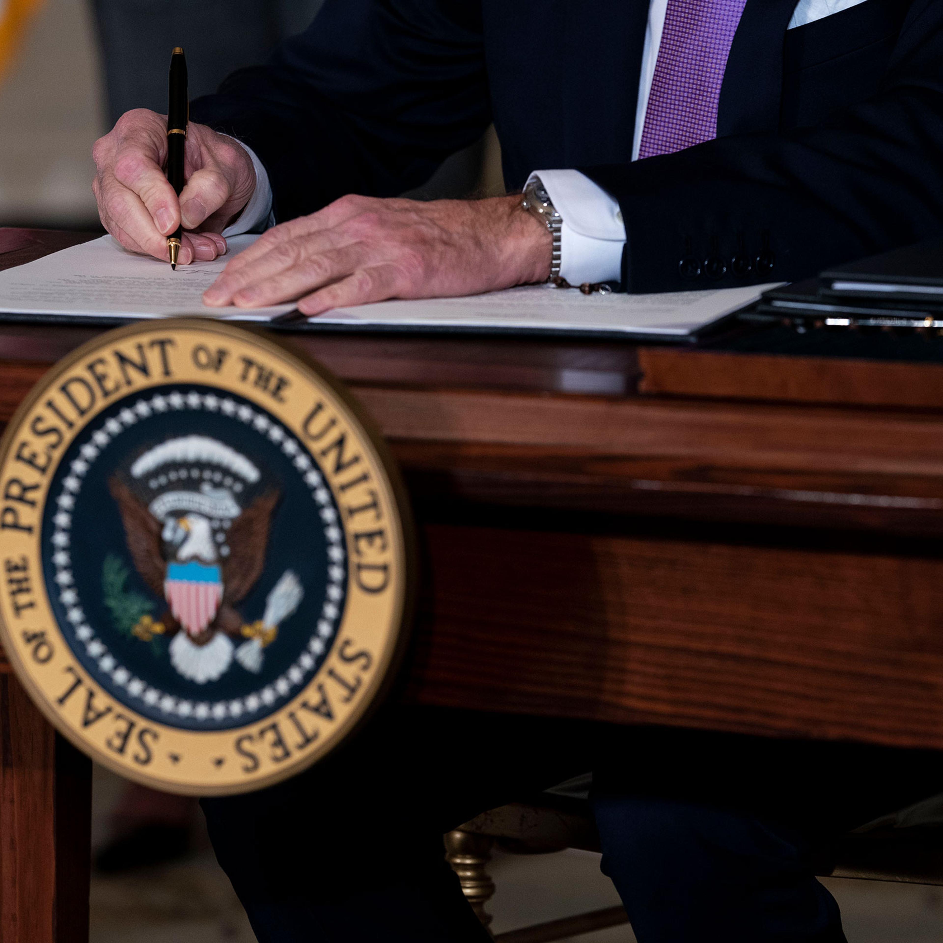 President Joe Biden signs the last of a series of executive actions during a ceremony at the White House in Washington on Jan. 26, 2021.