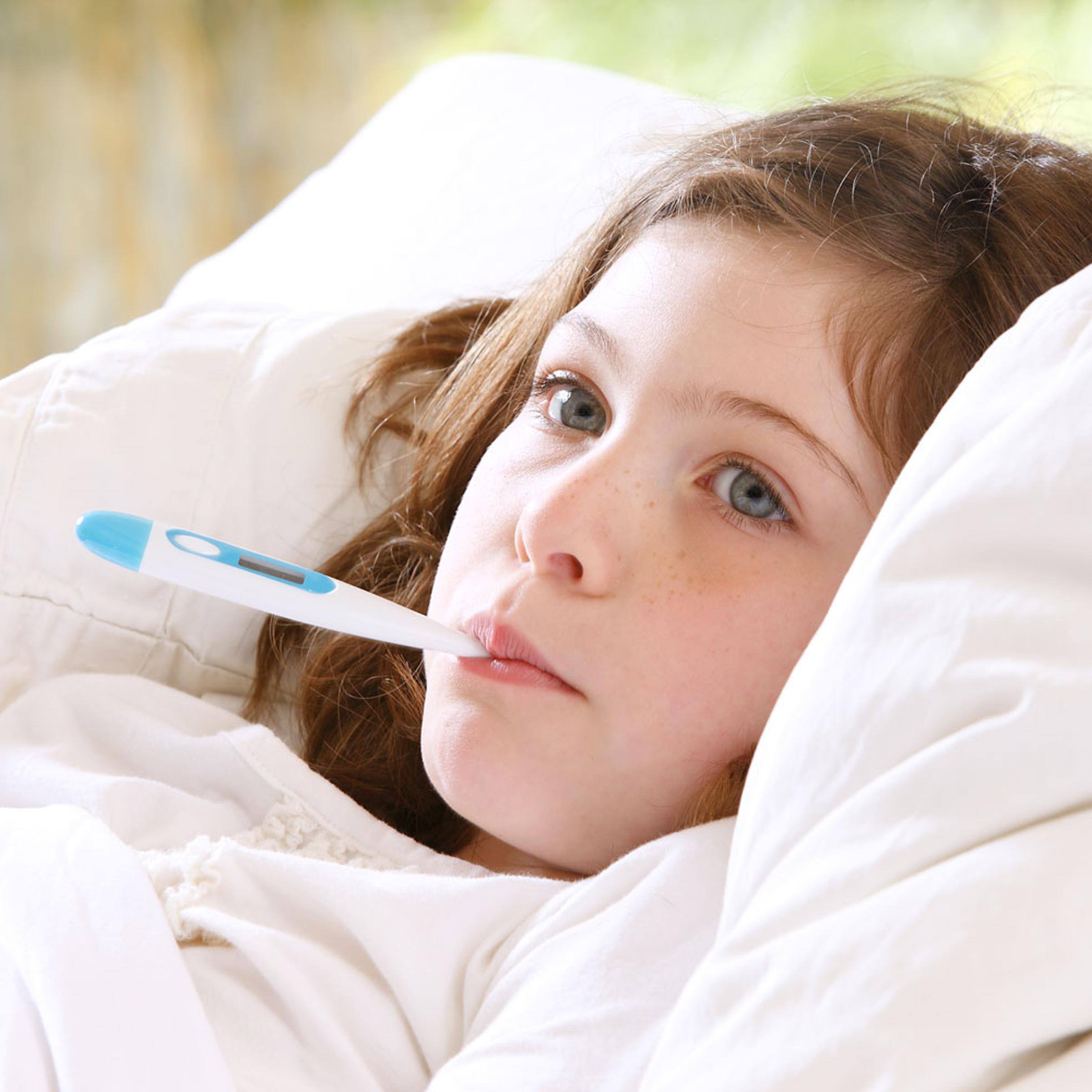 Girl in bed with thermometer in mouth